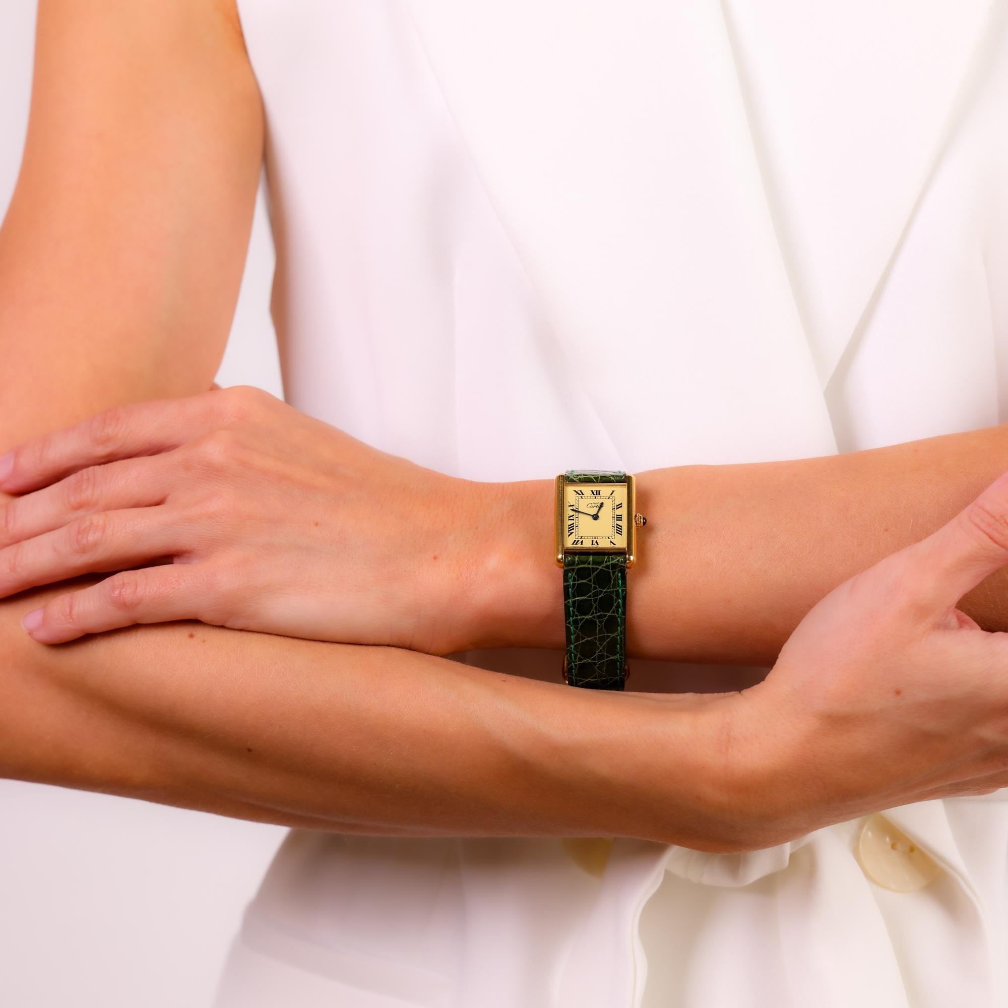 Diese Vintage-Uhr von Cartier Paris Tank verbindet zeitlose Eleganz mit einem vergoldeten Gehäuse, einem eleganten grünen Lederarmband und Akzenten aus Edelstahl.

Marke: Cartier Paris
Uhrwerk: Quarz
Metall: Vergoldete Silberuhr, Faltschließe aus