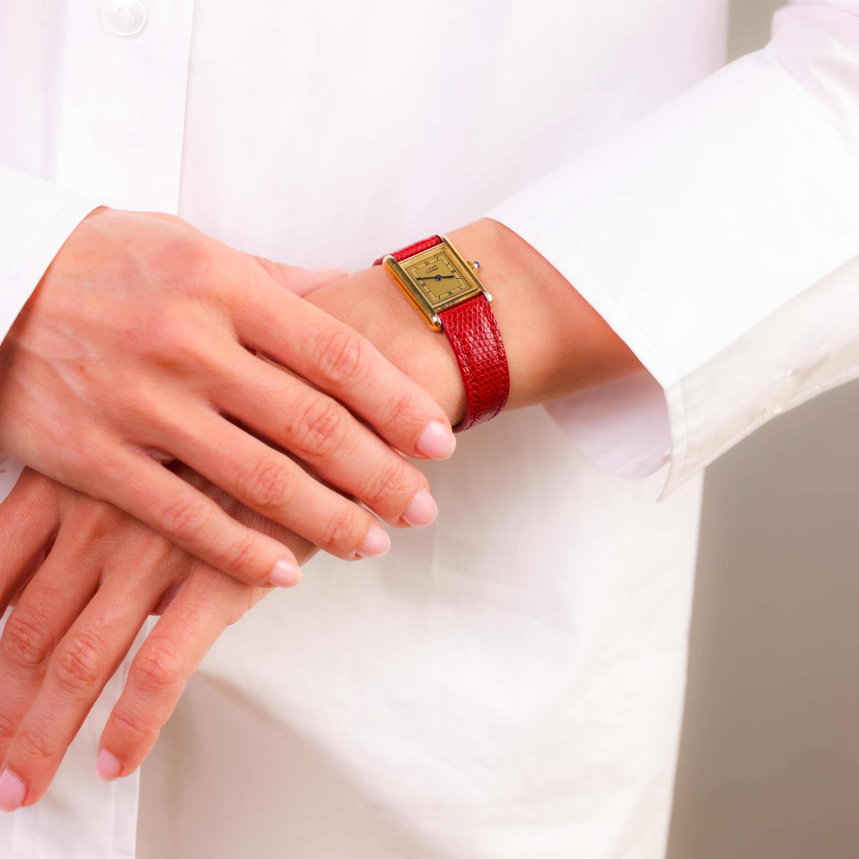 Cette montre vintage Cartier Paris associe un boîtier plaqué or à un bracelet en cuir bordeaux, offrant une élégance intemporelle et la précision d'un mouvement à quartz.