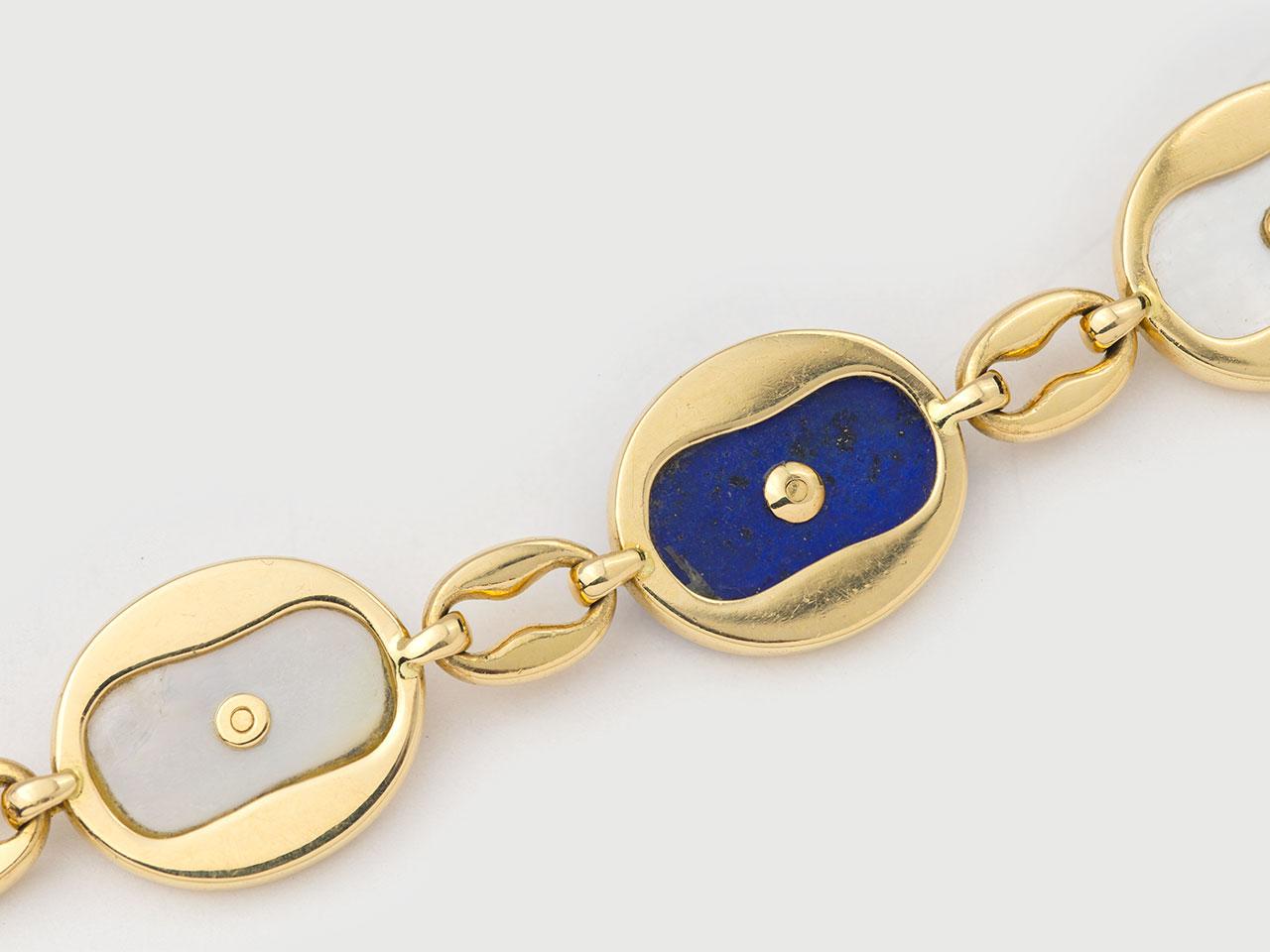 18k gold bracelet of mother of pearl and Lapis , centering a gold sun motif. CARITER PARIS 49429. 7-5/8 inches in length.