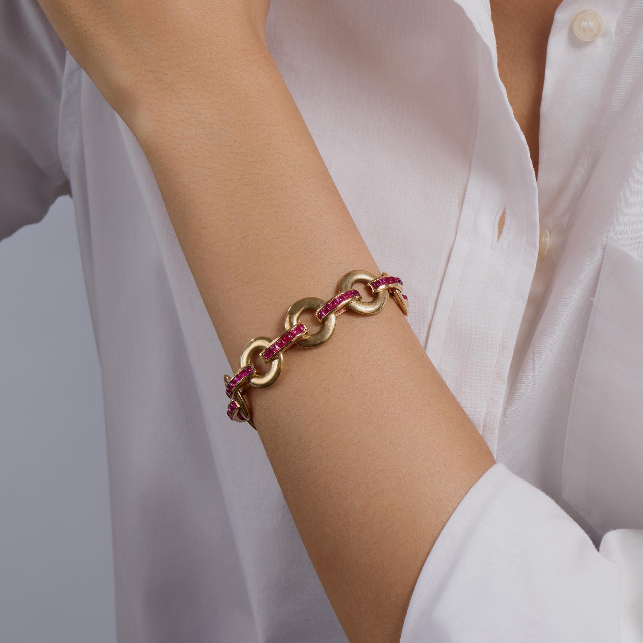 Created by Cartier Paris in the 1930s, this 18K gold bracelet is set with over five carats of rubies. It is composed of circular gold links joined by arched bars set with buff-top calibré-cut rubies. Beautifully weighted and set with blazing red