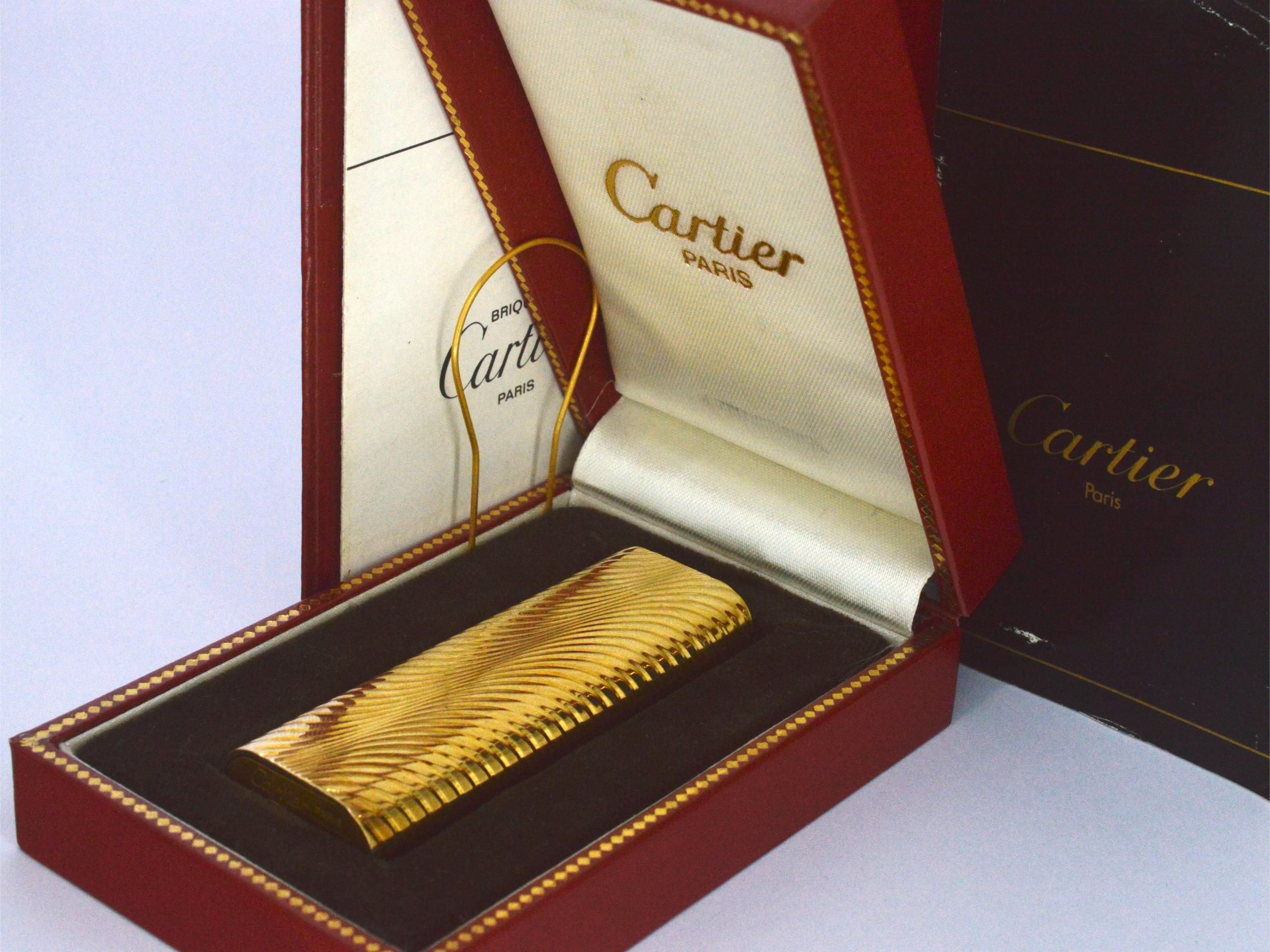 Dieses Vintage-Feuerzeug von Cartier Paris ist ein exquisites Schmuckstück mit einem Gewicht von 88,3 Gramm. Er ist vergoldet und besticht durch sein zeitloses Design, das Eleganz ausstrahlt. Trotz seines Vintage-Status ist es in gutem Zustand,