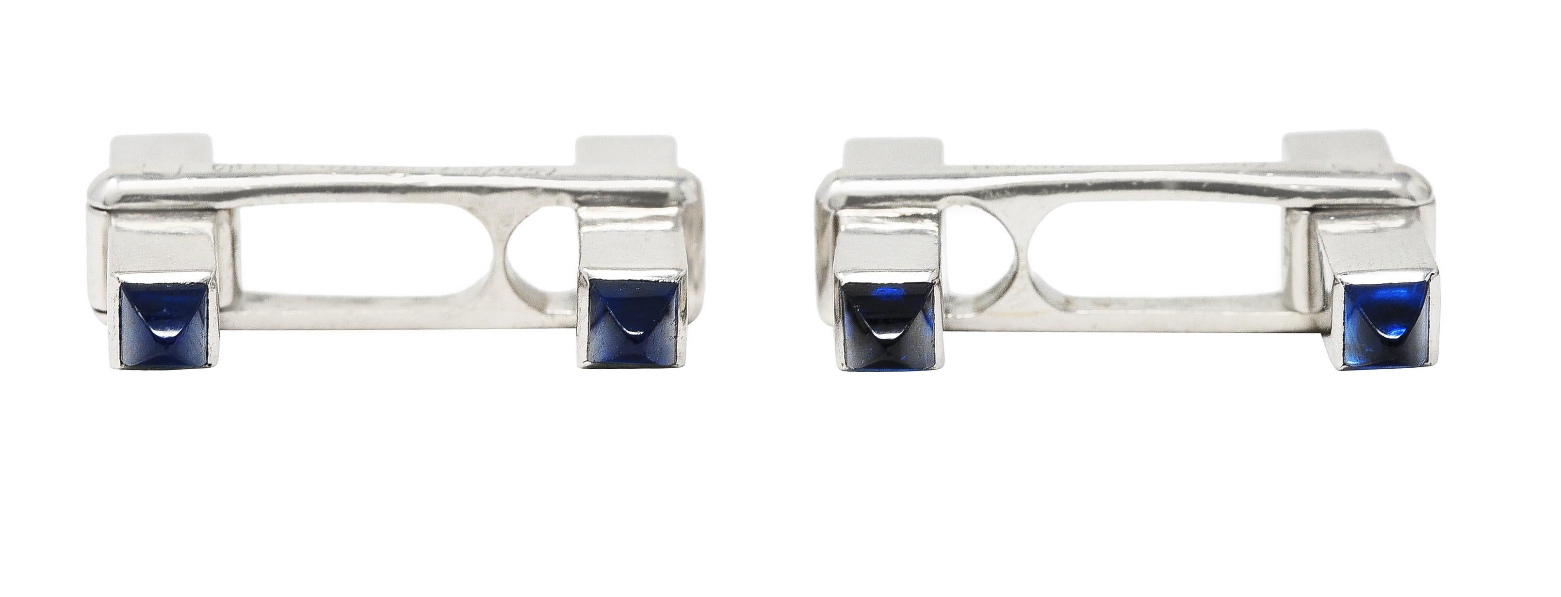 Designed as swivel style cufflinks comprised of rectangular bars. Terminating with carved pyramid shaped sapphire cabochons. Measuring 3.0 x 3.5 mm - transparent light to medium blue. Completed by high polished finish. Stamped with French hallmarks