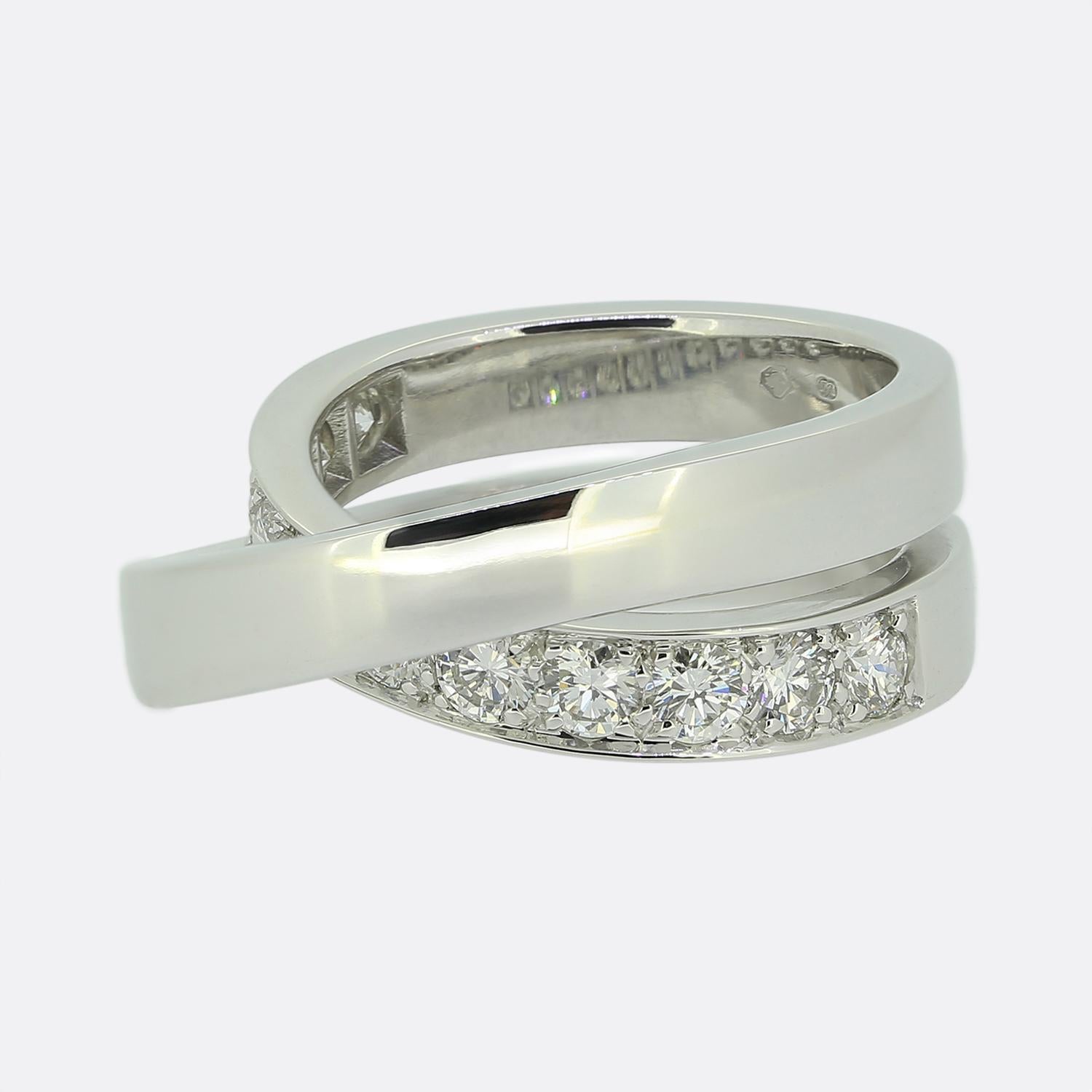 Ecco un favoloso anello di diamanti Paris Nouvelle Vague della famosa casa di gioielli di lusso Cartier. Questo elegante e classico design incrociato è composto da due fasce intrecciate, una delle quali è stata incastonata con undici diamanti