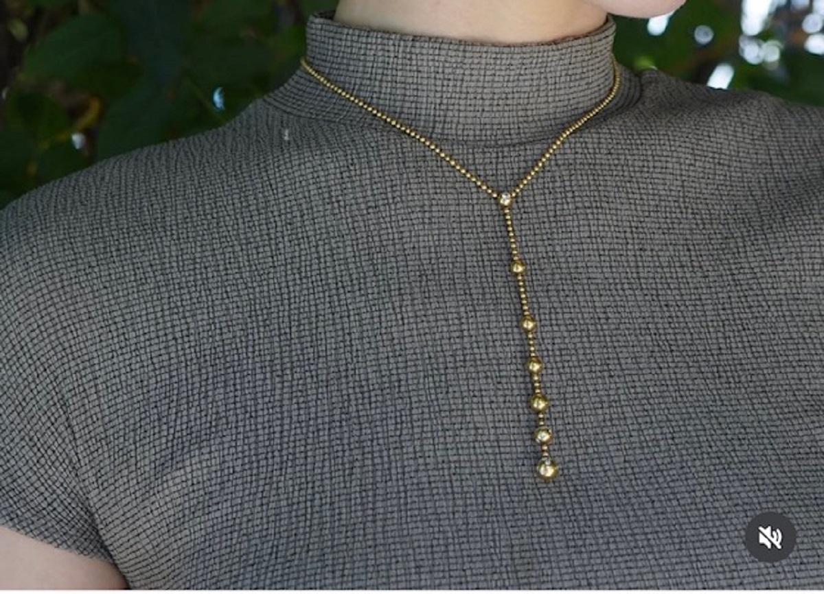 A beautiful Cartier Paris Nouvelle Vague lariat necklace, crafted of 18k gold, features diamonds. 
Thais Cartier lariat necklace is a refined yet playful piece. The design features a delicate ball chain that effortlessly drapes around the neckline,