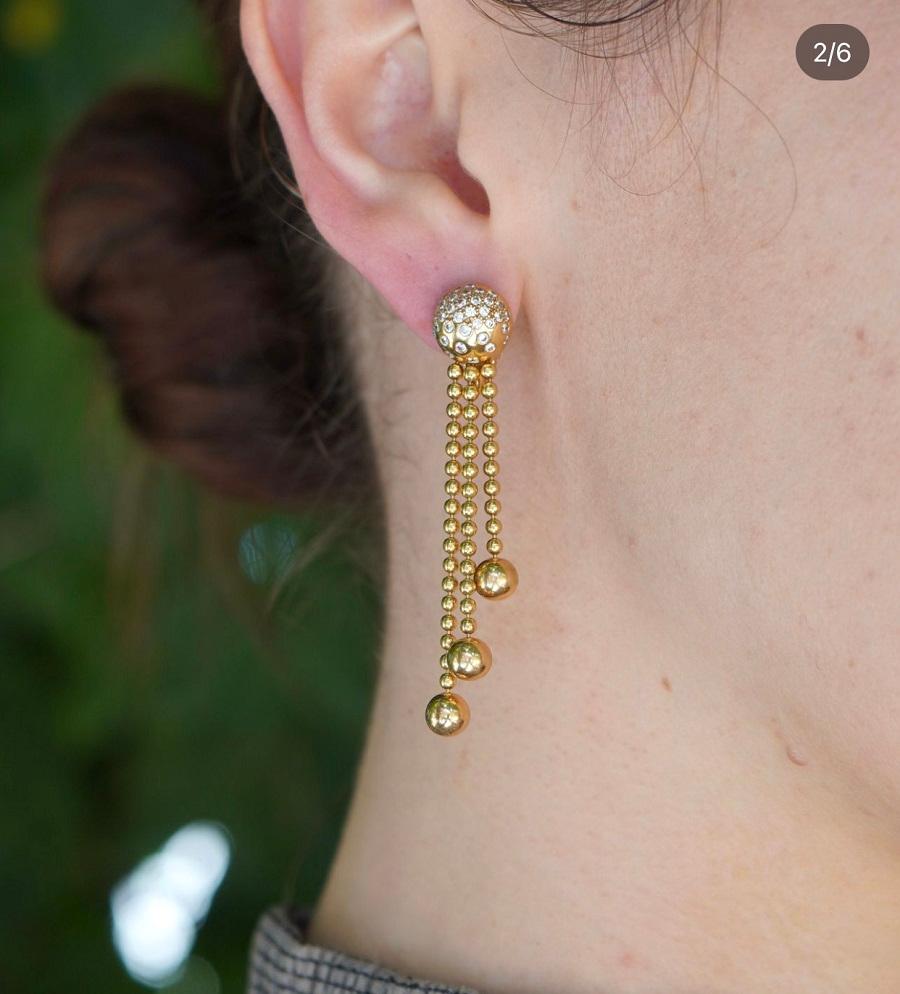 A gorgeous Cartier Paris Nouvelle Vague tassel earrings, made of 18k gold, featuring diamond.
The earrings feature a pair of diamond-encrusted spheres at the top, totaling approximately 0.80 points. Cascading from each sphere are delicate gold bead