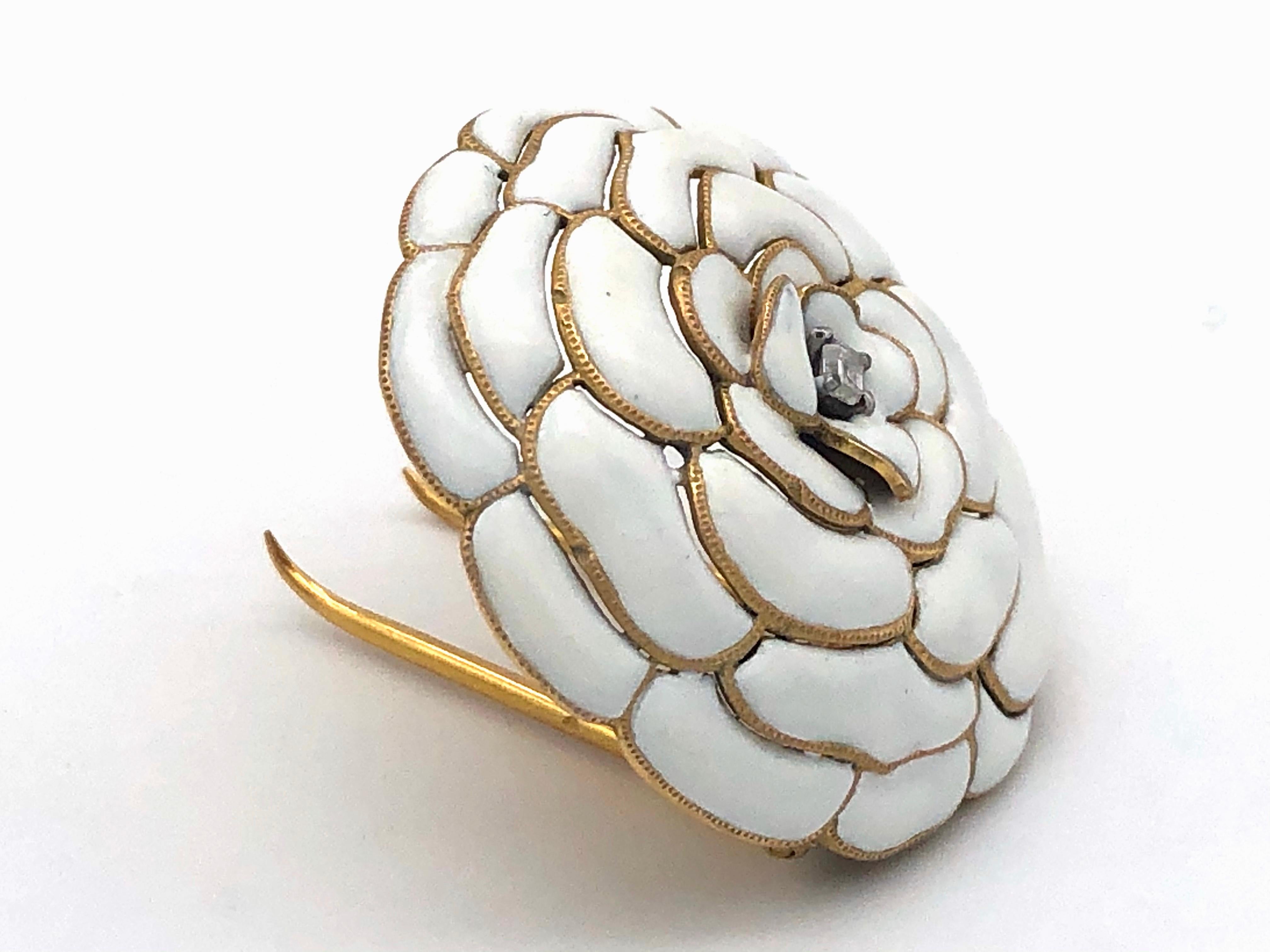 Spring feelings all year round with this stunning Cartier dressclip designed as a white camelia in full bloom.
Golden petals, painted with opaque white enamel, are arranged around a rectangular diamond held by four platinum claws. The petals have a