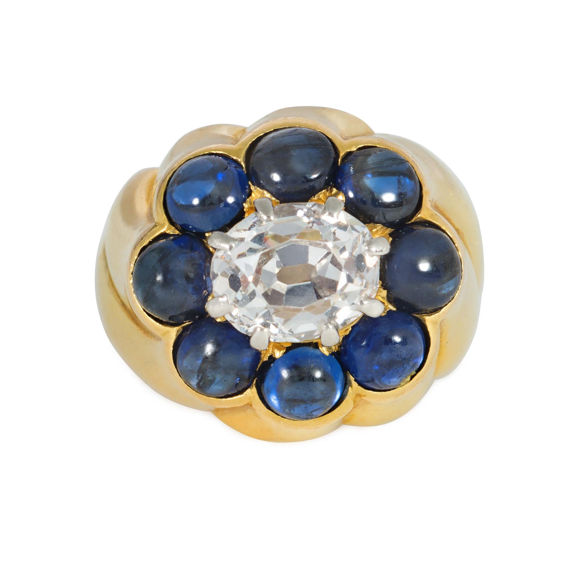 A Retro gold, sapphire, and diamond ring, the mount of fluted design and centering on an inset stylized florette of cabochon sapphires surrounding a diamond, in 18k. Cartier, Paris. Monture #. Atw diamond 1.61 cts. For a similar item, see Amazing