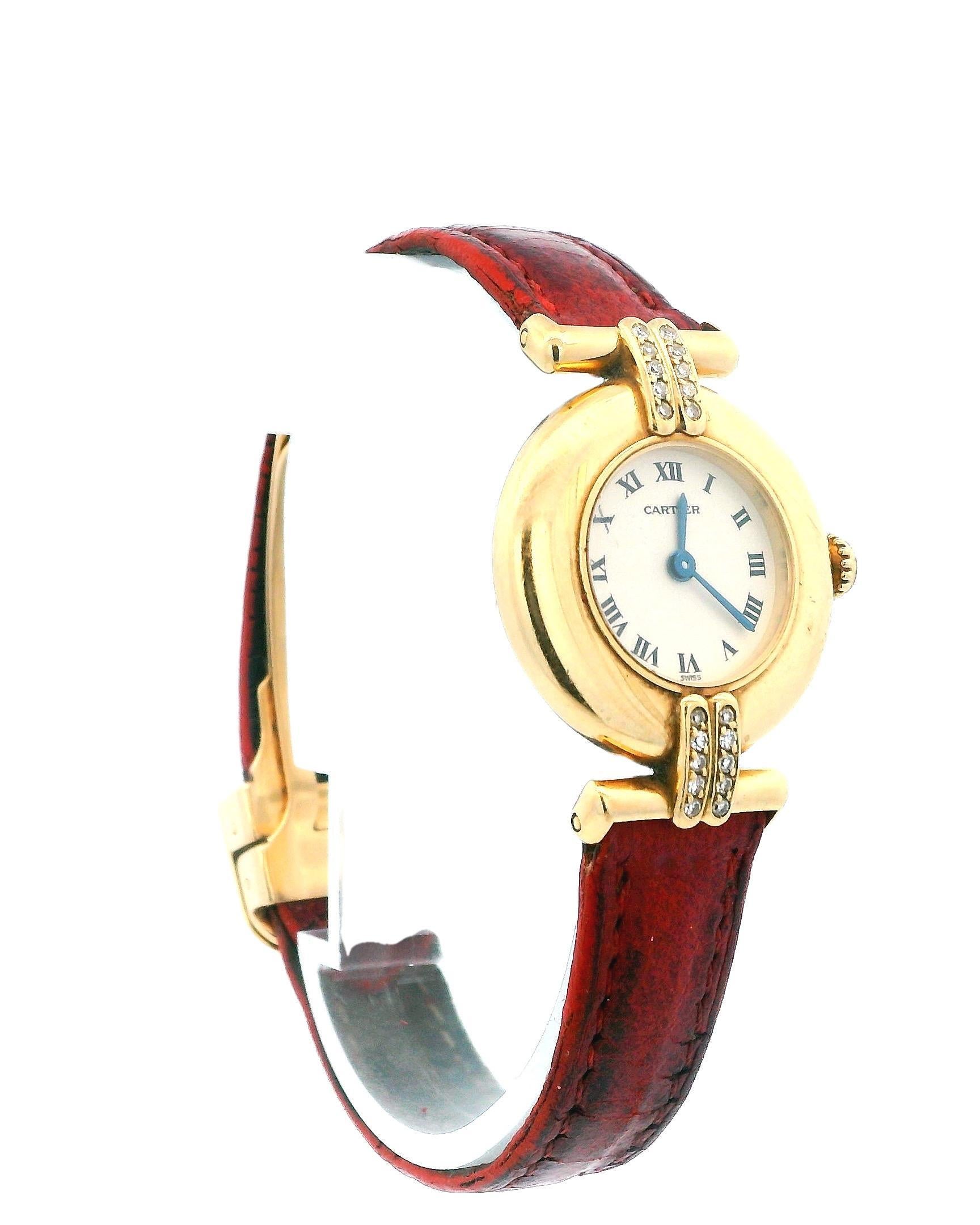 Cartier Paris Rivoli ladies watch. 24MM 18K yellow gold case size with factory lugs diamond. Silver dial with blue hands and black Roman numeral hour marker. 18K yellow gold case back. Red leather strap with 18K yellow gold deployment clasp fits up
