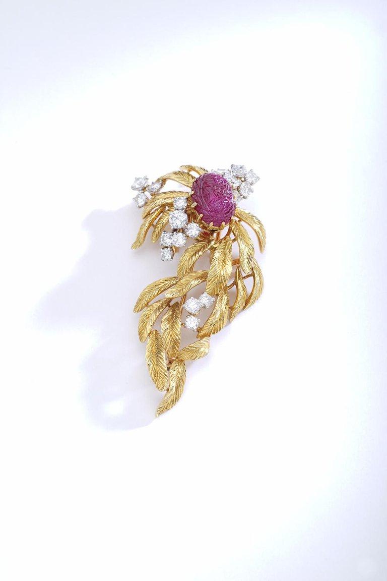 Cartier Paris Fantastic Brooch centered by a Ruby Burmese carved on a diamond and yellow gold Brooch. The Ruby is convertible as an individual Pin.
Signed, numbered and marked.
Circa 1960.