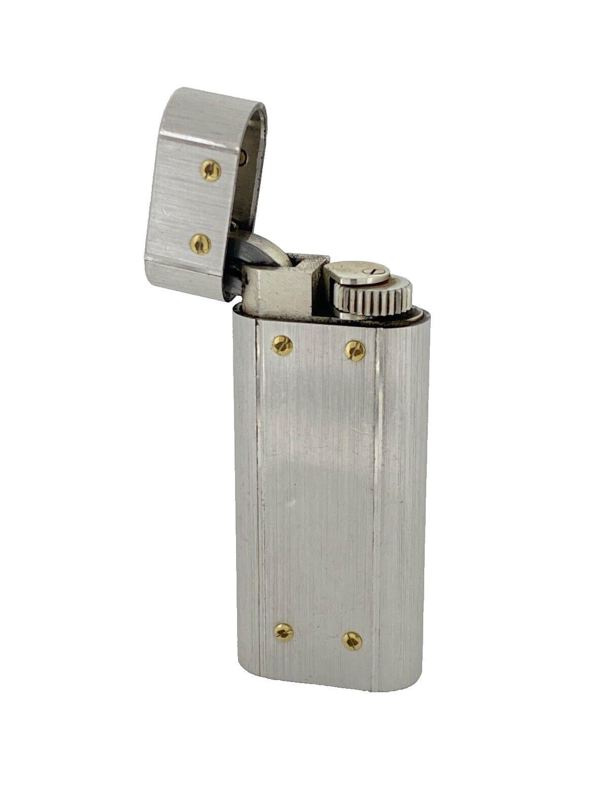 Fine & Rare Vintage Cartier Santos Lighter, 
Stainless Steel 
with 12 Signature Gold-Plated Screws
Satin finish 

Signed “Cartier Paris”, hallmarked & numbered to the base 

58mm (H) x 26mm (W)