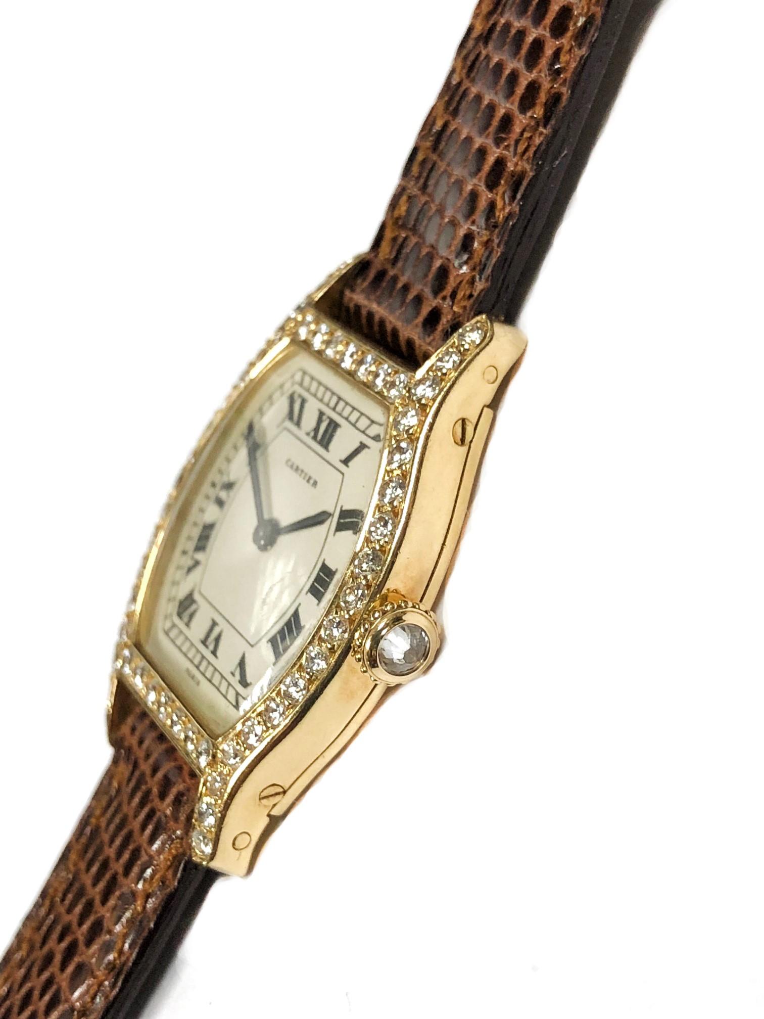 Circa 1990s Cartier Paris Tortue Collection Ladies Wrist watch. 30 X 23 MM 18K yellow Gold Case with Cartier Factory set Diamond Bezel, lugs and Crown. Mechanical, Manual wind Movement, Silver White Dial with Black Roman numerals. New 1/2 inch wide