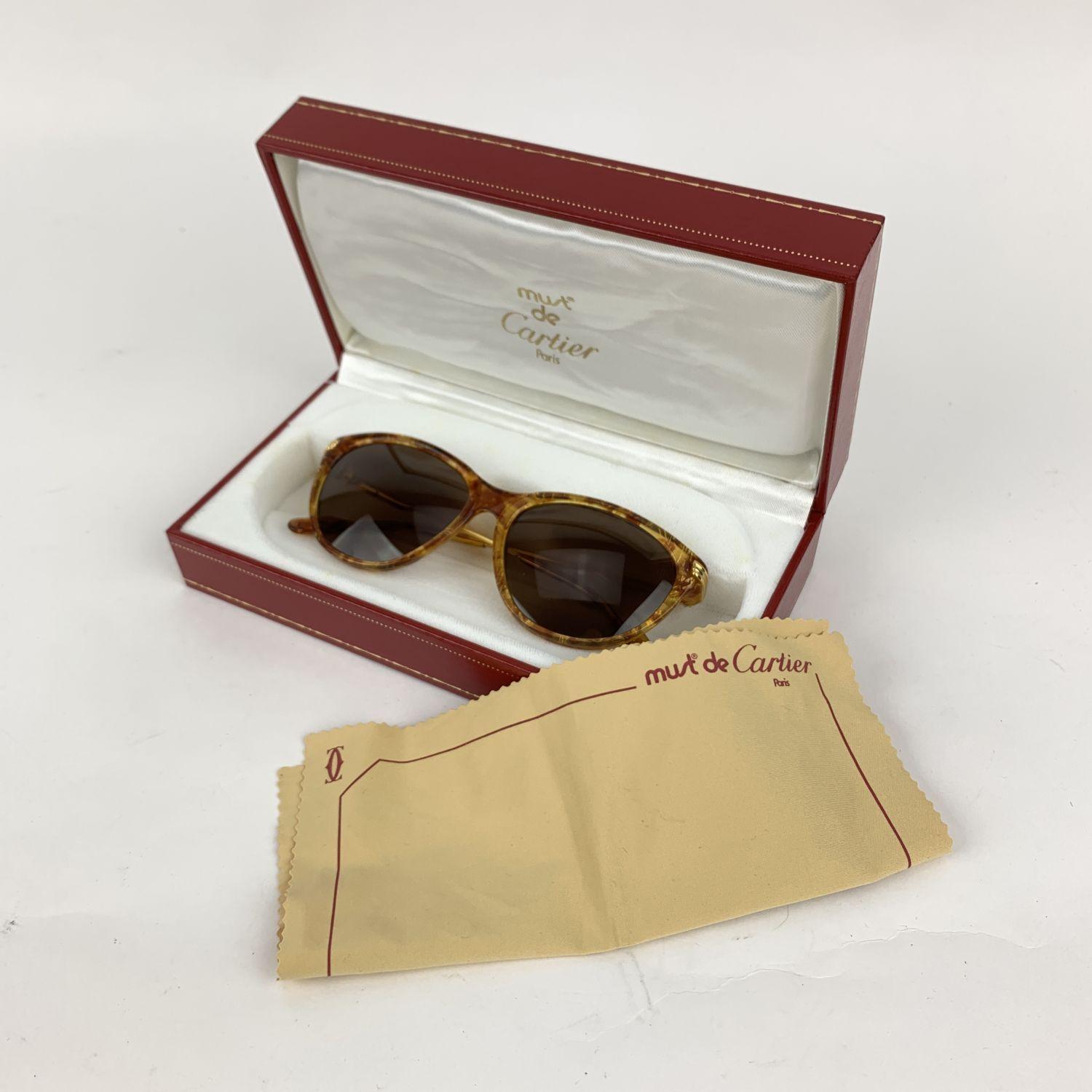 Tortoise acetate eclat miel dore Cartier sunglasses from the 90s. Lightweight Full-Rim Frame. 22kt Gold Plated Frame Original Cartier Brown Lens, Original Box and suede cleaning cloth.

Details

MATERIAL: Gold Plated

COLOR: Brown

MODEL: Eclat Miel