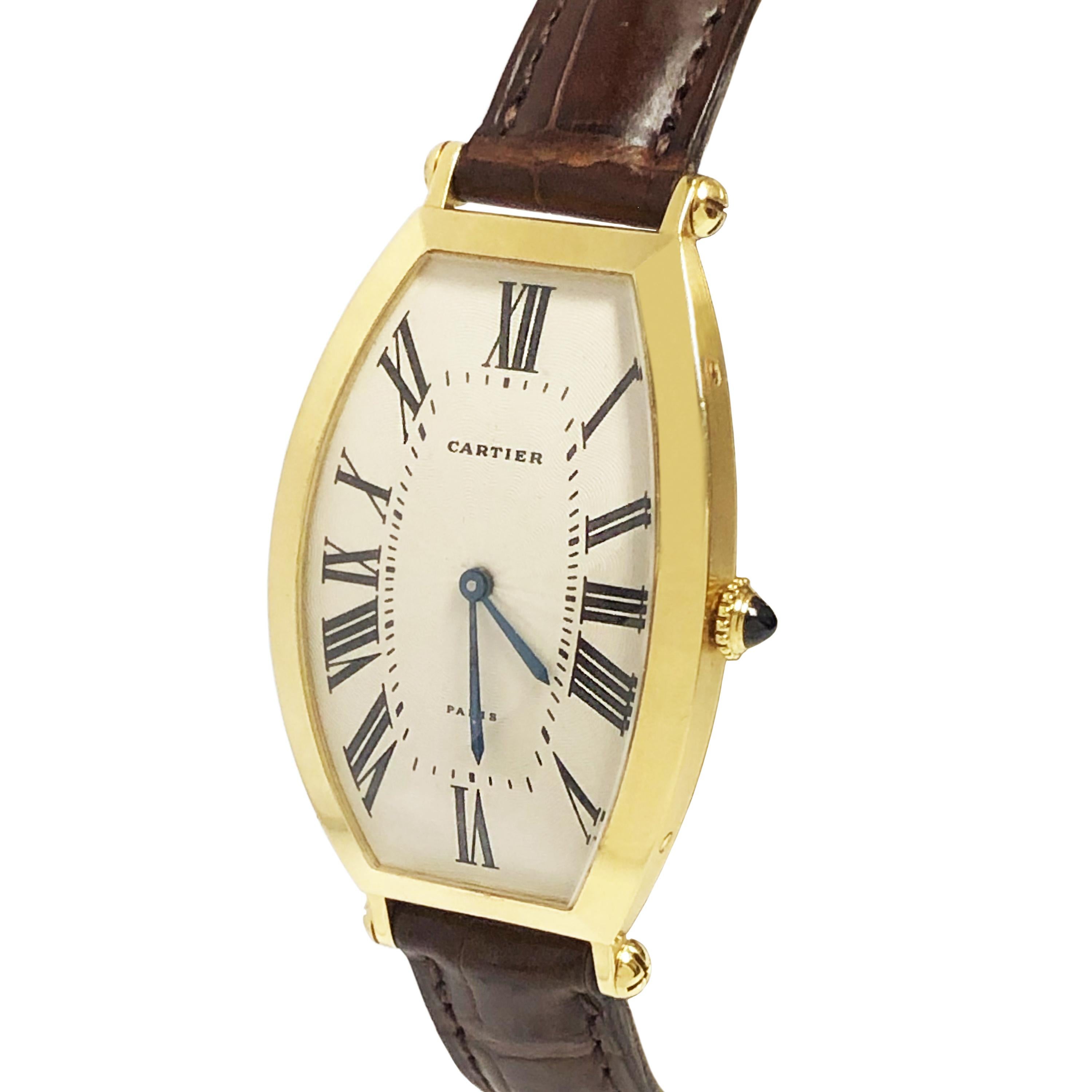 Circa late 1980 Cartier Paris Tonneau Wrist Watch, 46 X 26 Curved and Convex 18K Yellow Gold 2 Piece case. 17 Jewel Mechanical, Manual wind Movement, Sapphire Crown, Engine Turned Silver Dial with White Finish and Black Roman NUmerals. Cartier Brown