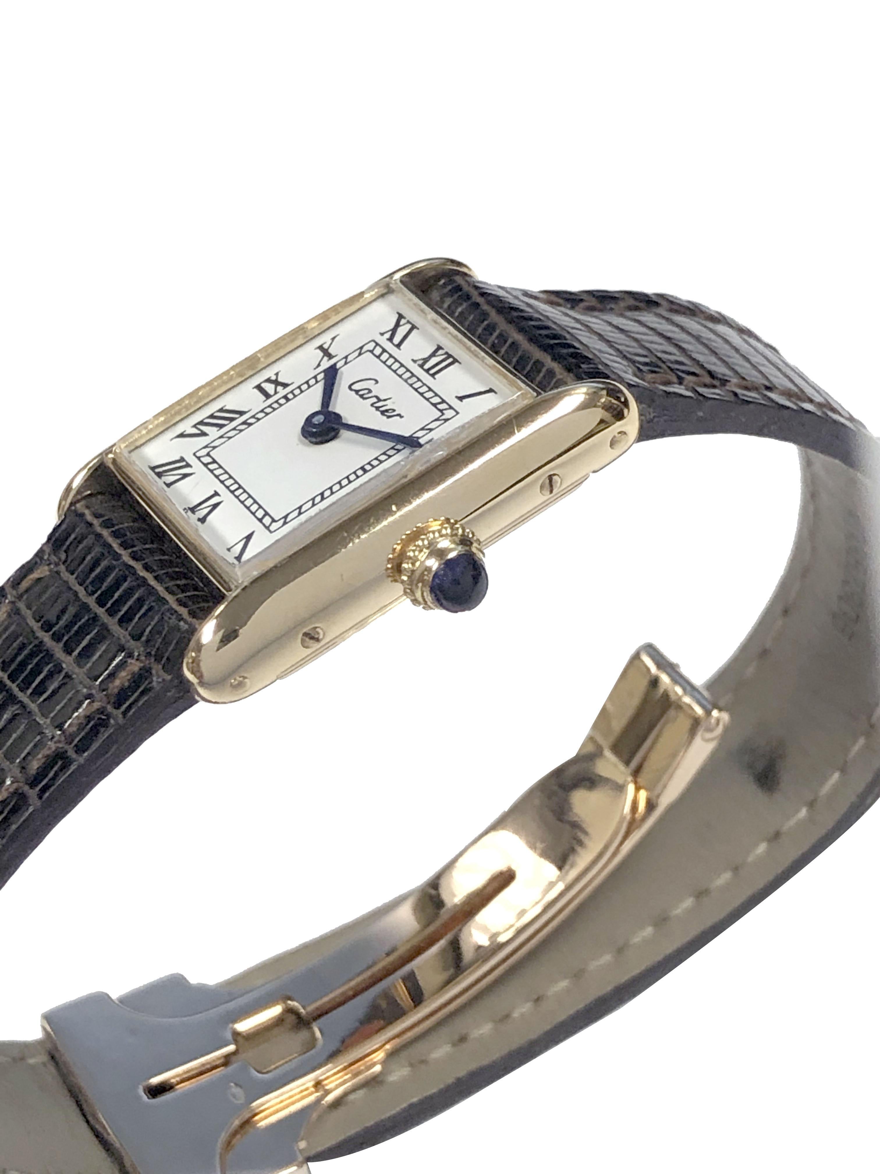 Circa 1970s Cartier Paris Ladies Wrist Watch, 25 X 19 M.M. 2 piece 18K Yellow Gold case, Mechanical, manual wind movement, White Dial with Black Roman Numerals, Sapphire crown. Newer Cartier Brown Lizard Strap with original Cartier 18k Deployment