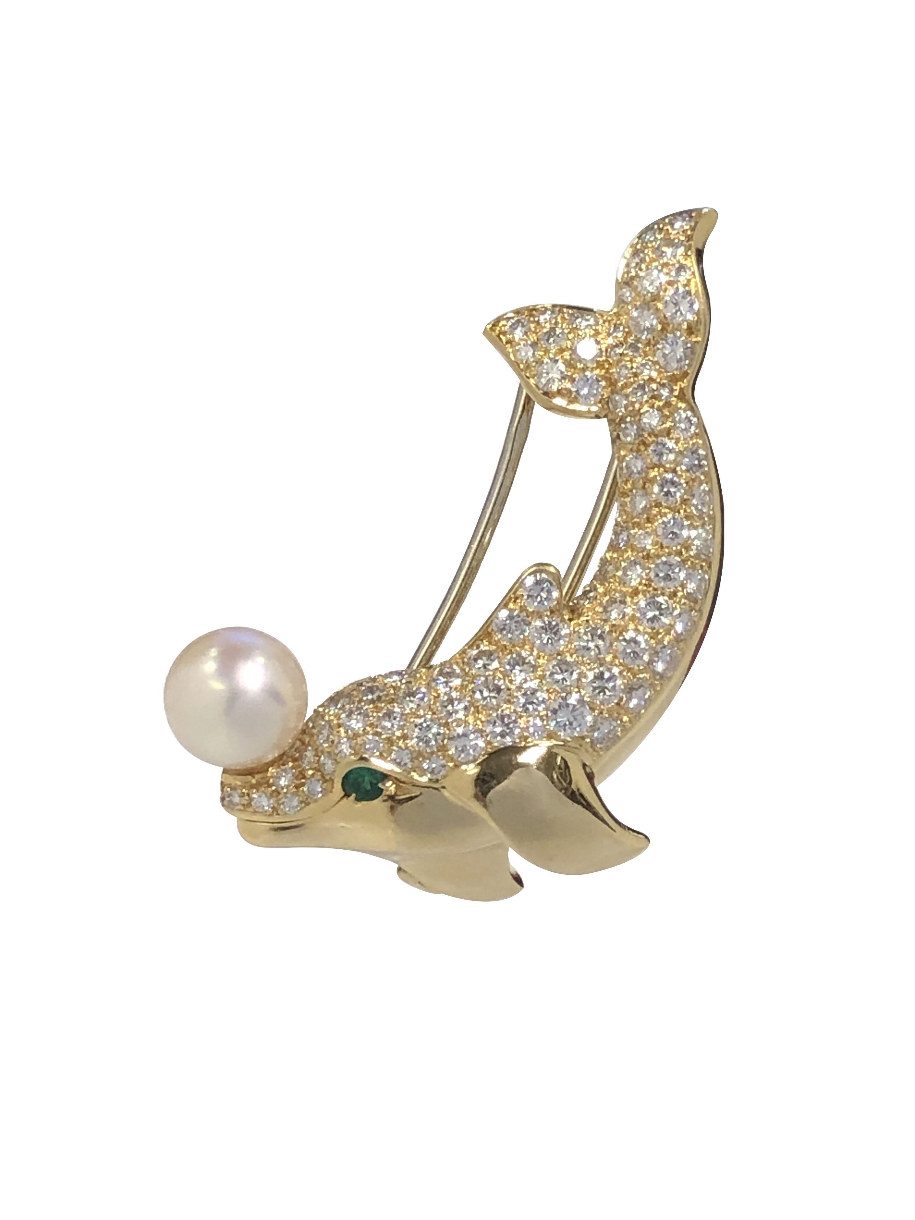 Circa 1990s Cartier Paris Whimsical Dolphin Clip Brooch, measuring 1 1/2 inches in length X 1 inch, set with Round Brilliant cut Diamonds totaling 3.50 Carats, further set with an Emerald Eye and a fine 7 M.M pearl balanced on the Dolphins nose.