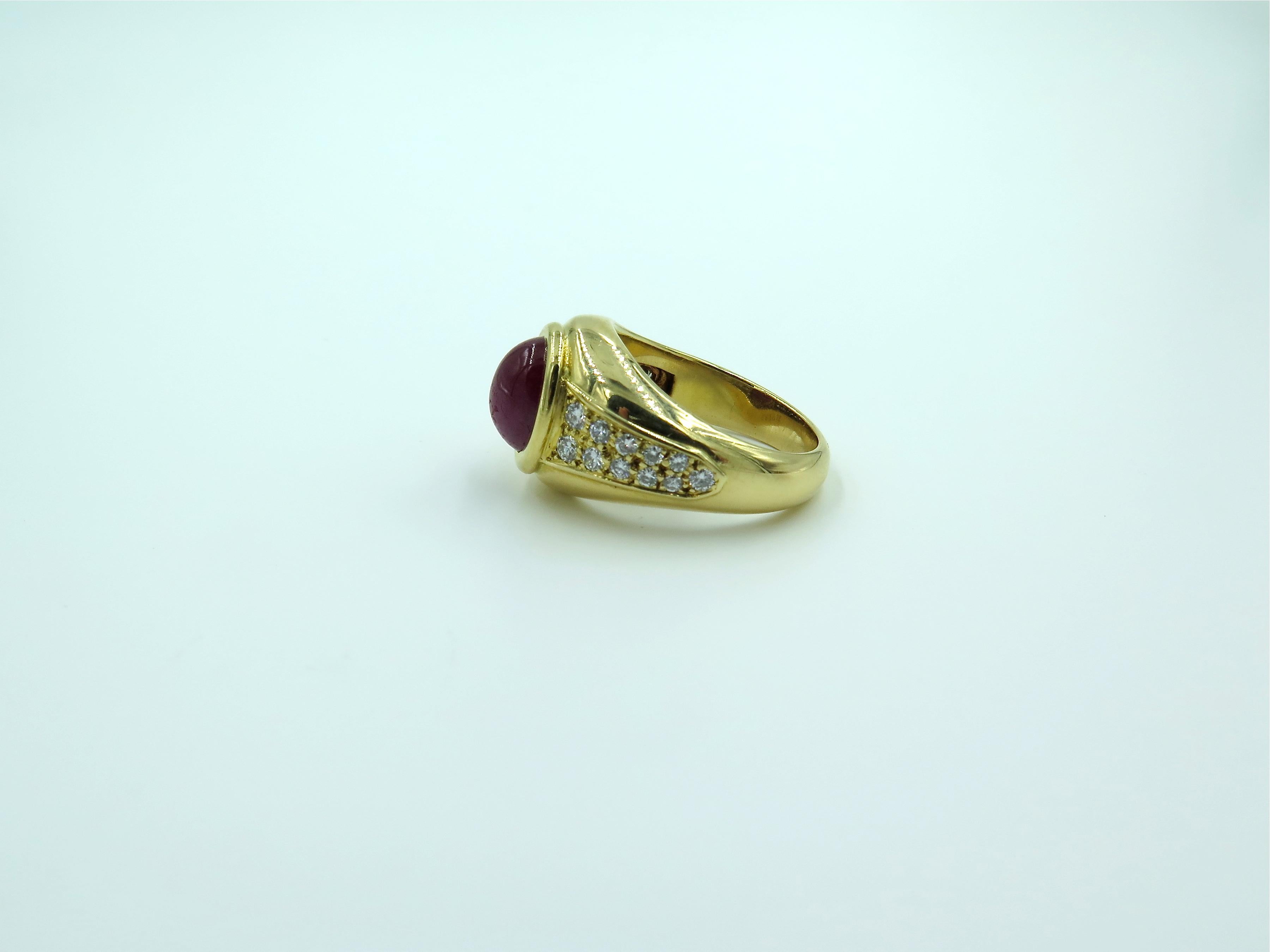 A yellow gold ruby and diamond ring. Cartier, Paris. The tapering bombe band centering an oval cabochon ruby, measuring approximately 8.6 x 6.9 x 4.2mm, and weighing approximately 2.60 carats, enhanced by pave set diamond shoulders. Twenty two (22)