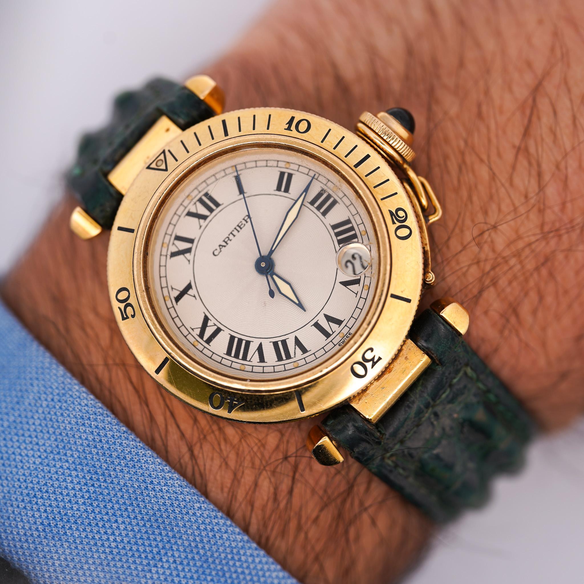 Cartier Pasha 1035 automatic watch in 18K yellow gold featuring a 35mm round case with ivory dial, bold black Roman numerals, blued steel hands, and date aperture at 4 o'clock. Complete with matching 18K yellow gold Cartier deployment buckle and