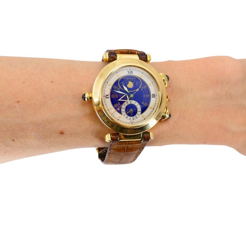 A Cartier Pasha Alarm Moonphase watch, reference # 30011. Designed by Gérald Genta.

Crafted from 18k yellow gold, the 38mm case is secured with a screw-down back fastened by nine screws, ensuring a water resistance of up to 30 meters. It runs on a