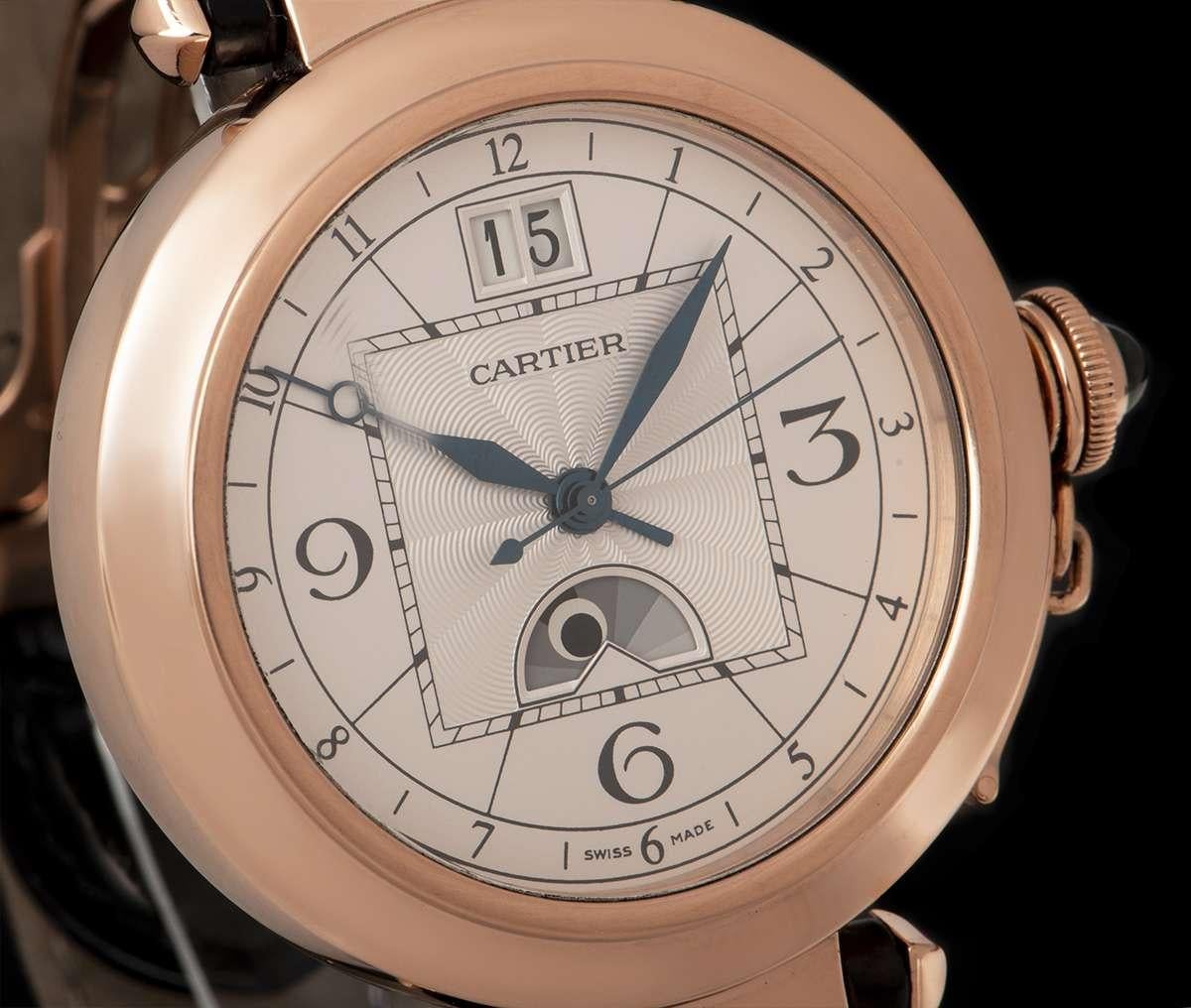 An 18k Rose Gold Pasha de Cartier Gents Wristwatch, silver dial with a guilloche centre, hour markers and arabic numbers 3, 6 and 9, day and night indicator at 6 0'clock, date at 12 0'clock, blued steel hands, a fixed 18k rose gold bezel, an 18k