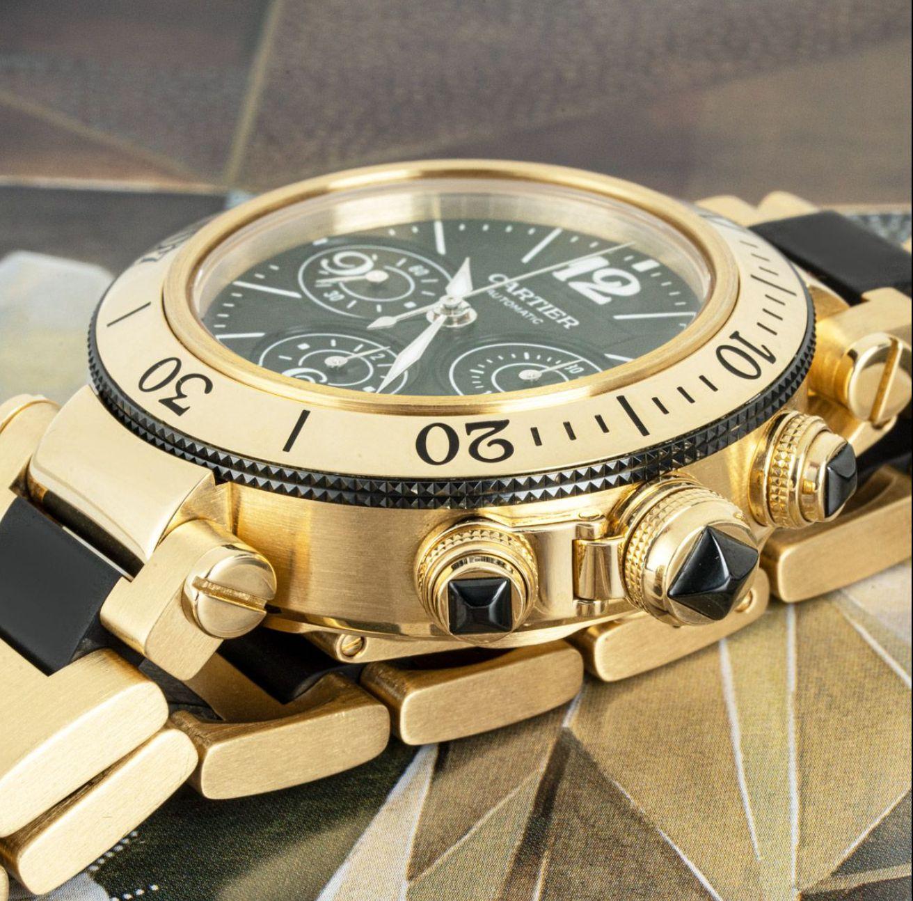 Une montre-bracelet Cartier Pasha Seatimer en or jaune de 42 mm. Cadran noir avec chiffres arabes, 3 compteurs de chronographe et un guichet de date. Le cadran est complété par une lunette tournante en or jaune et une couronne protégée par un