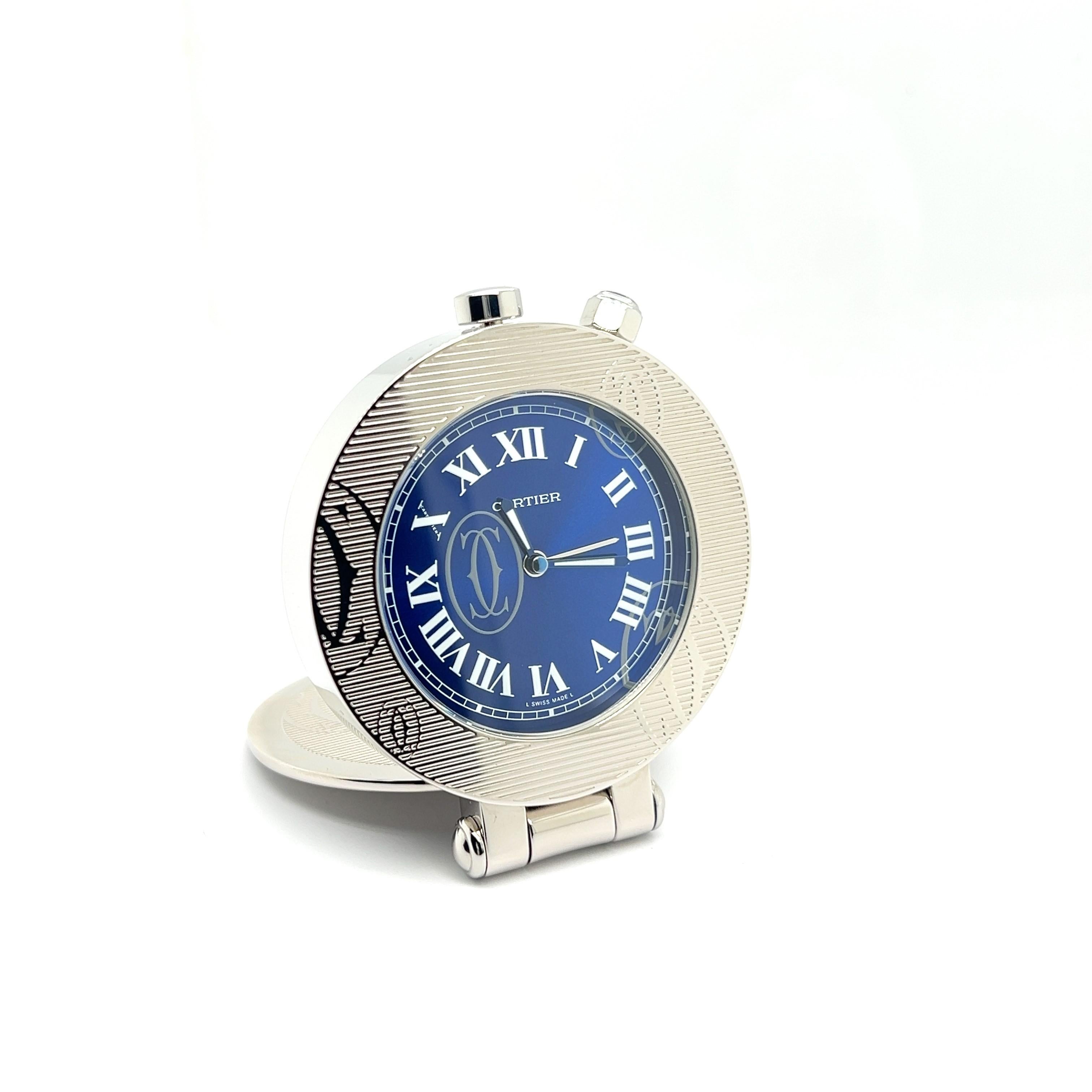 Elevate your journey with the Cartier Pasha Stainless Steel Travel Alarm Clock. 

This exquisite timepiece blends Cartier's iconic design with practical sophistication. Its blue dial and elegant Roman numerals exude timeless class. Encased in