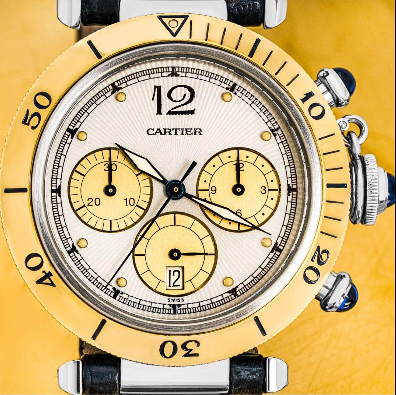 A yellow gold Pasha wristwatch by Cartier. Featuring a silver dial with arabic number 12, champagne set chronograph counters and a date aperture. Complementing the dial is a yellow gold uni-directional bezel and crown protected by a screw-down cover