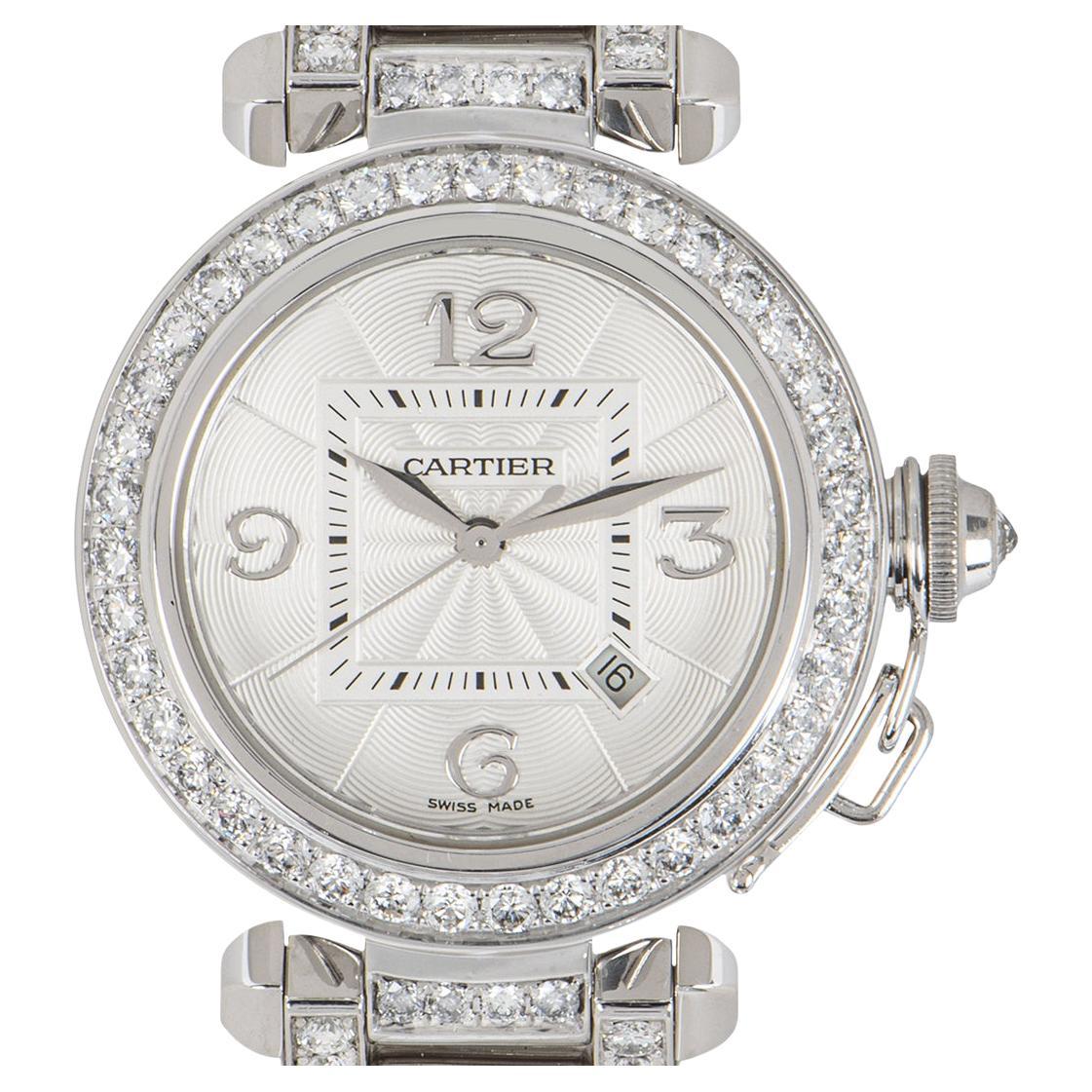 A stunning ladies 32mm Pasha wristwatch, crafted in 18k white gold by Cartier. Featuring a silver guilloche dial with white gold arabic numbers and a date display. Complimenting the dial is a fixed white gold diamond set bezel and crown. 

Fitted