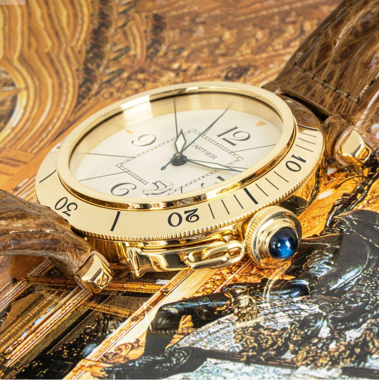 A 38mm yellow gold Pasha by Cartier. Featuring a silver dial with arabic numbers, sword-shaped hands in blued steel and a date aperture. Complimenting the dial is a yellow gold rotatable bezel with a crown protected by a screw-down cover which is