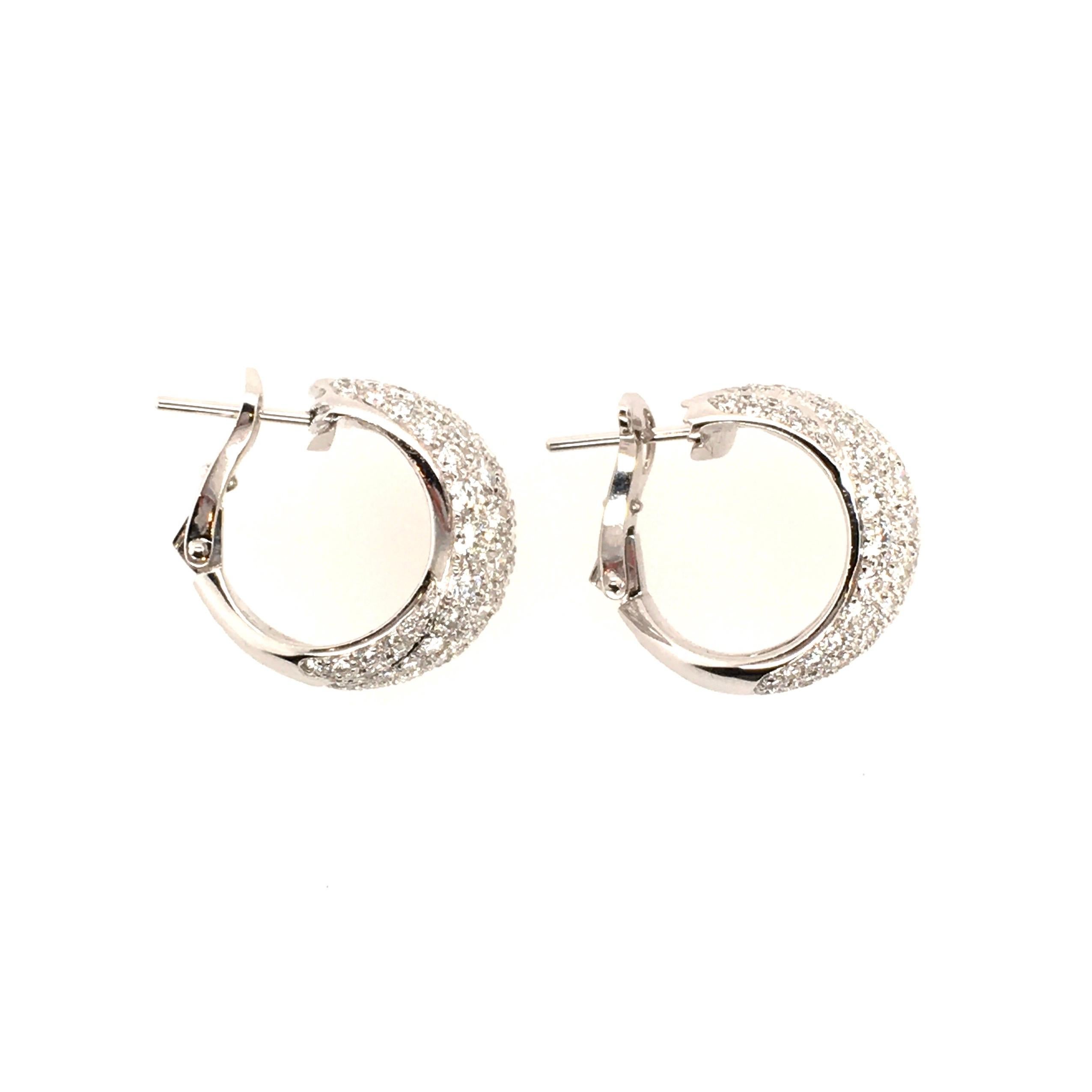 A pair of 18 karat white gold and diamond earrings. Cartier. Designed as a pave set hoop of overlapping design. One hundred and seventy eight  diamonds weigh 3.00 carats. Length is approximately 3/4 inches, gross weight is approximately 12.0 grams.