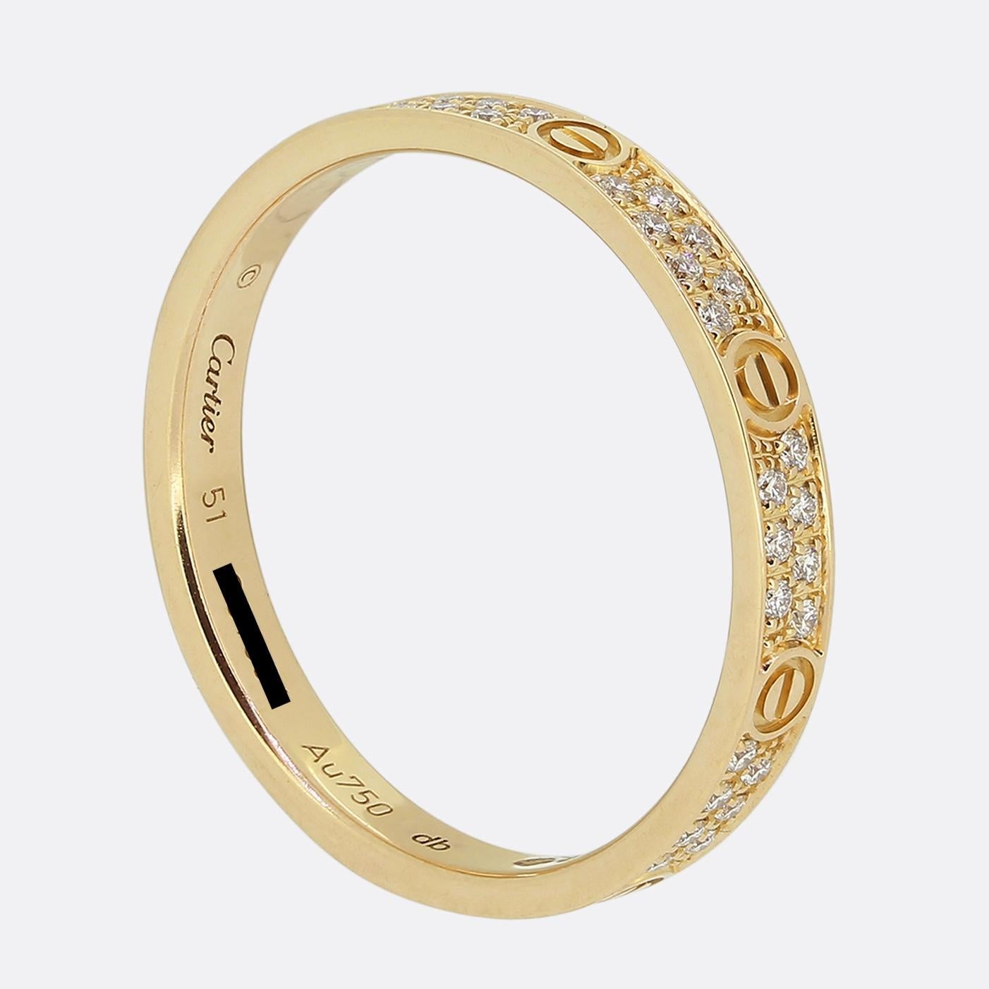 Here we have a wonderful band ring from the world renowned luxury jewellery house of Cartier. This 18ct rose gold piece forms part of their LOVE collection and features two rows of round brilliant cut pave set diamonds alongside the iconic screw