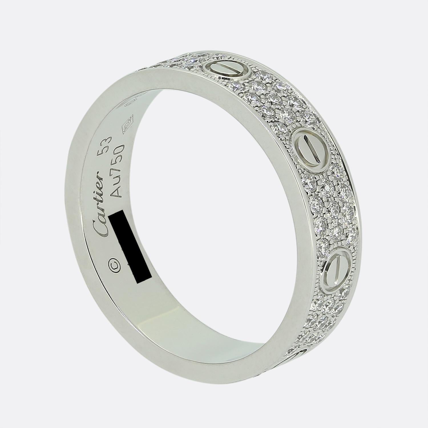 Here we have an 18ct white gold band ring from the world renowned luxury jewellery house of Cartier. This ring forms part of their LOVE collection and showcases a consistent alternating design around the entire band featuring three pave diamond set