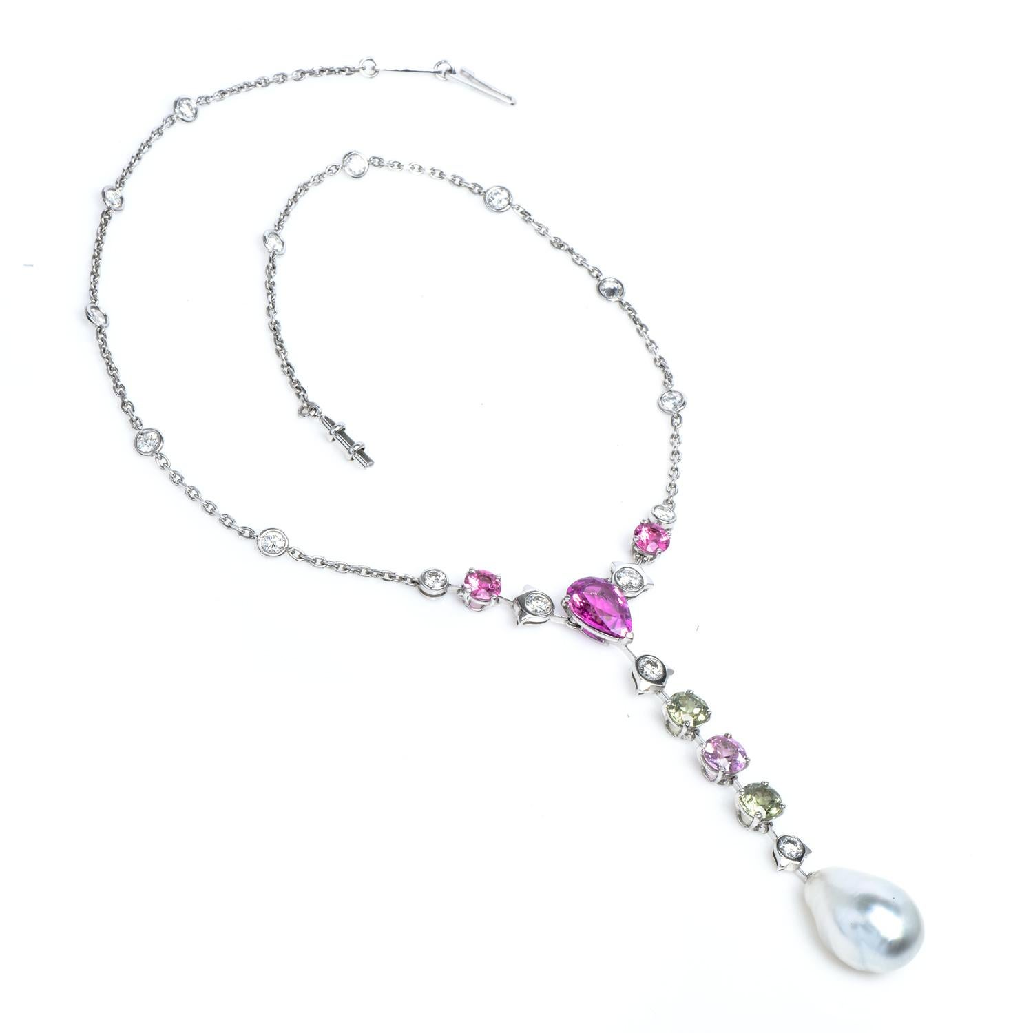 Set with a drop-shaped Semi Batouque natural white saltwater pearl measuring approximately 13.58x 12.15mm, to a line surmount decorated with a pear-shaped natural pink sapphire weighing 3.50 carats, spaced by two Peridot, pink sapphires, and
