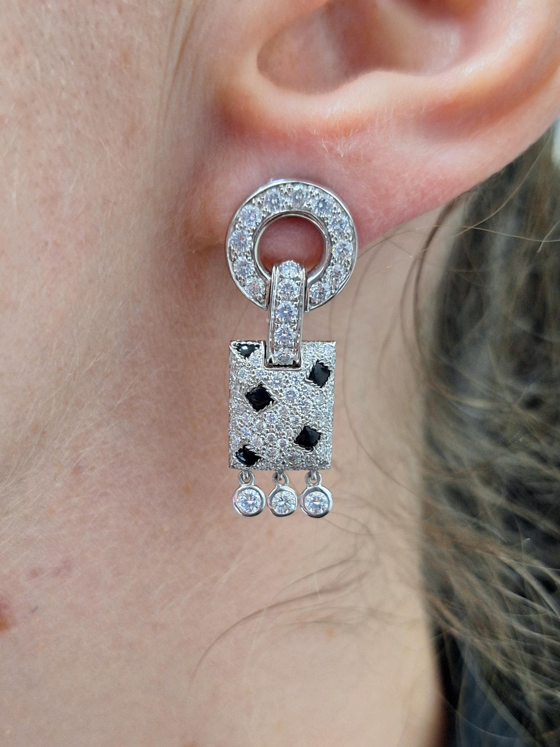 Cartier Pelage Panthère earrings crafted in 18 karat white gold. Each earring is set with high quality round cut diamonds and cabochon onyx for an estimated 2.40 carats total diamond weight. The alluring mix of diamonds and onyx mimic the skin of a