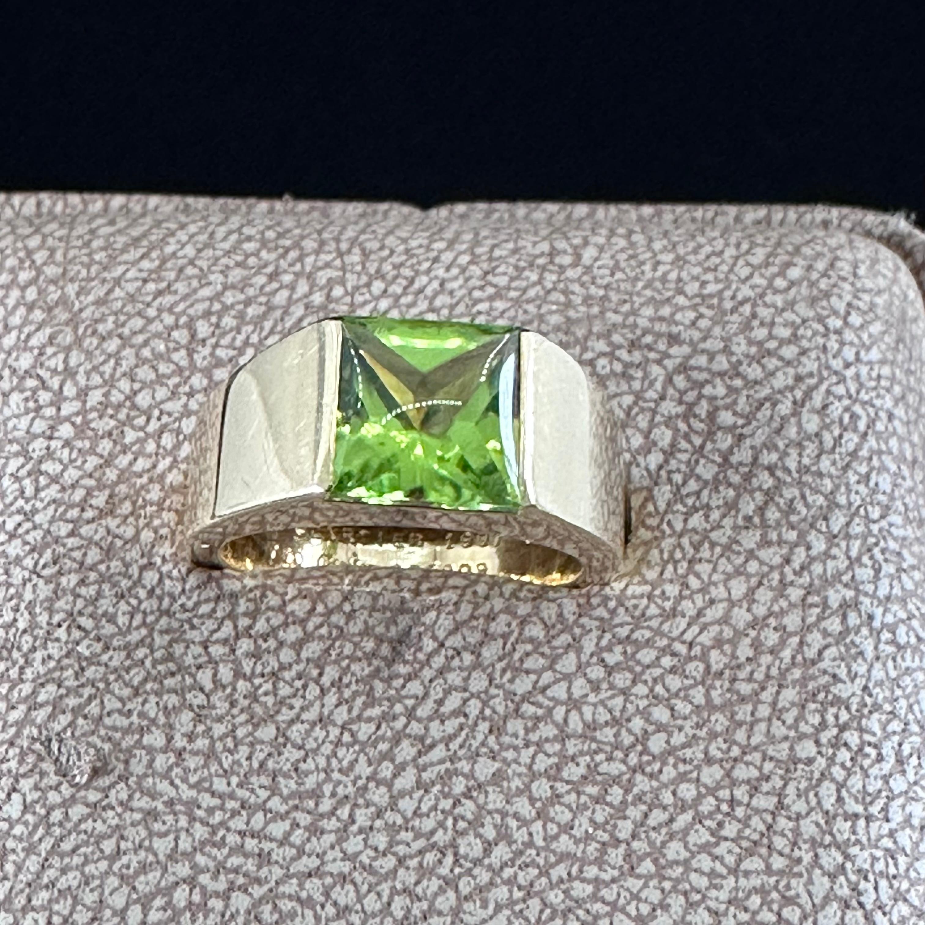 Vintage Cartier Vivid Peridot Tank Band Ring 
Size: 51
1997 Cartier French Hallmarks 750 
The iconic tank ring.
Square Cabochon Peridot Set Open Tension Setting.
Handsome Made in France
18 k Yellow  Gold 
Geometric Band Ring
Dimensions of the