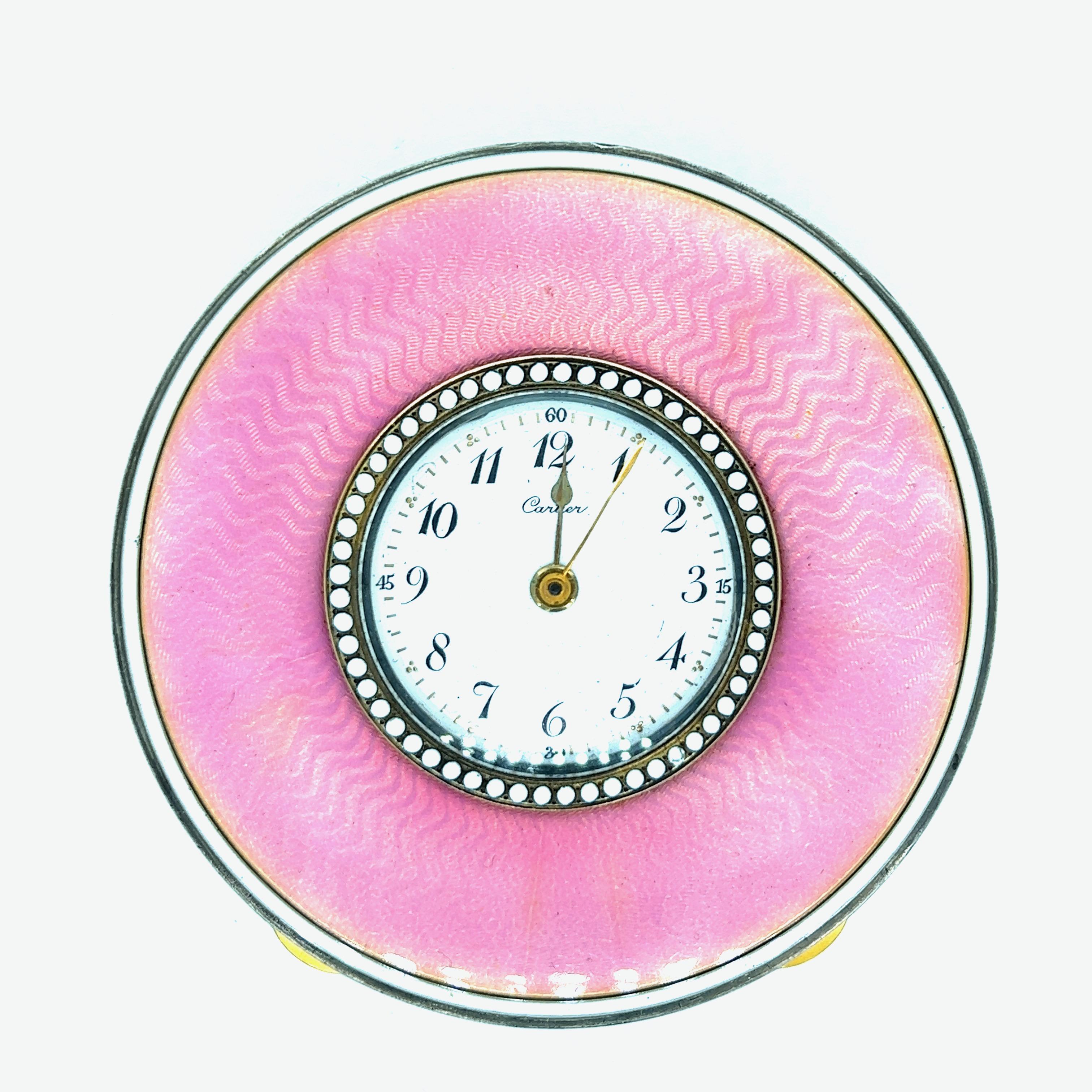 Cartier pink enamel desk clock, circa 1910s

Circular-shaped dial with Arabic numerals, white enamel dotted bezel surrounding the dial, pink guilloché enamel case with white enamel border; marked Cartier

Size: diameter 2.68 inches
Total weight: