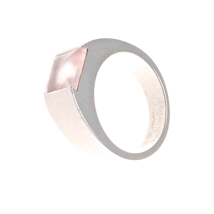 The sleek and modern Tank ring from Cartier. Featuring a single glowing pink cabochon cut quartz that is complementing by smooth lines of solid 18k white gold. Signed Cartier and numbered.