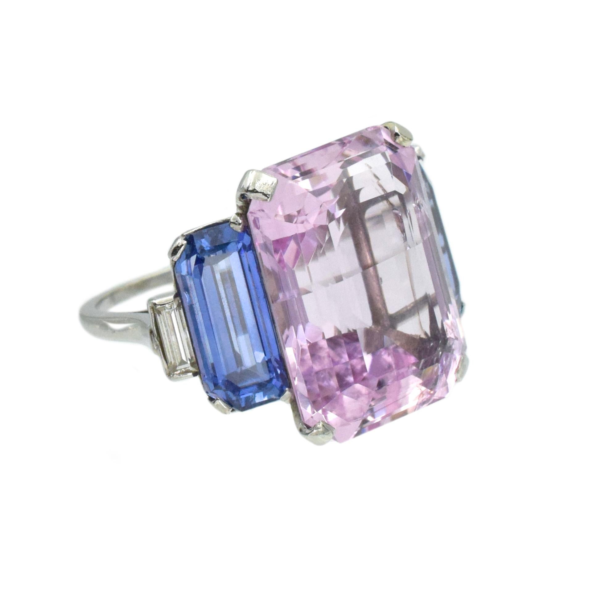 Cartier pink topaz, blue sapphire and diamond ring in platinum. Center set with cut-cornered rectangular step-cut pink topaz weighing approximately 24.08 carat. flanked by 2 cut- cornered rectangular step-cut sapphires weighing total of