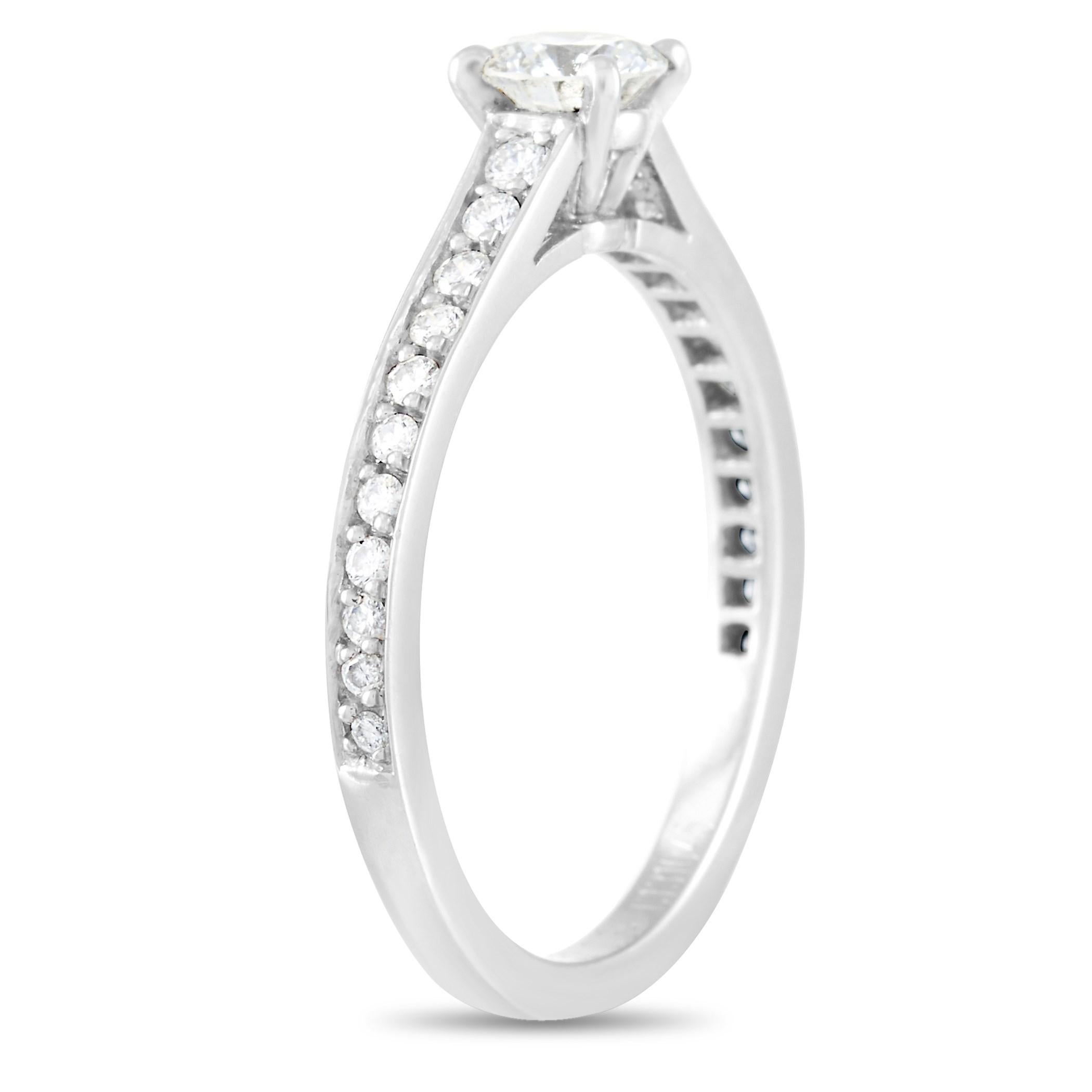 This Cartier Platinum 0.49 ct Diamond Solitaire Engagement Ring is made with platinum and features a 0.34 carat round-cut solitaire center diamond held by four prongs and flanked by 0.15 carats of round-cut diamonds set in the band. The band