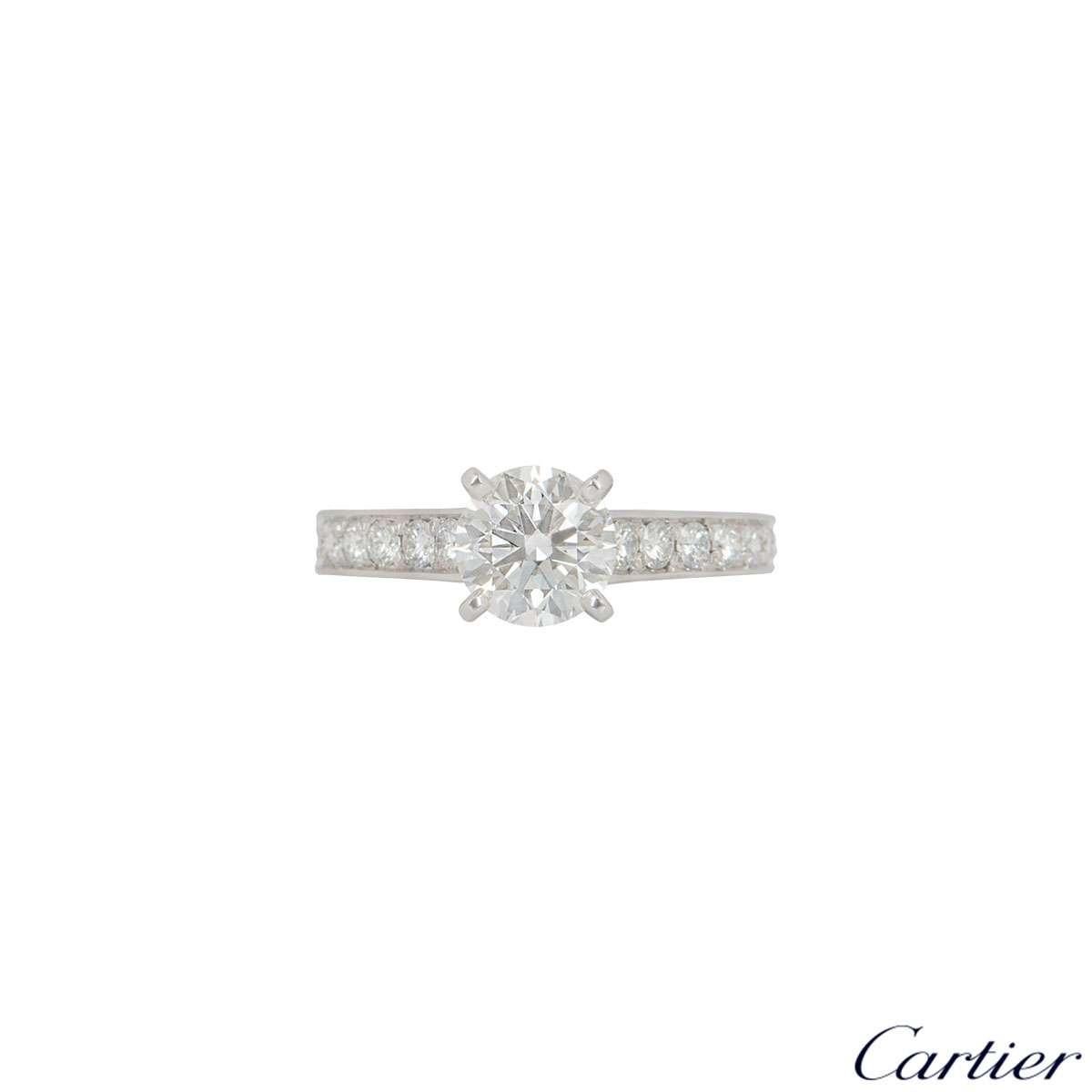 A stunning platinum Cartier diamond engagement ring from the 1895 solitaire collection. The ring comprises of a round brilliant cut diamond in a four claw setting with a weight of 1.22ct, G colour and VVS1 clarity with 9 round brilliant cut diamonds