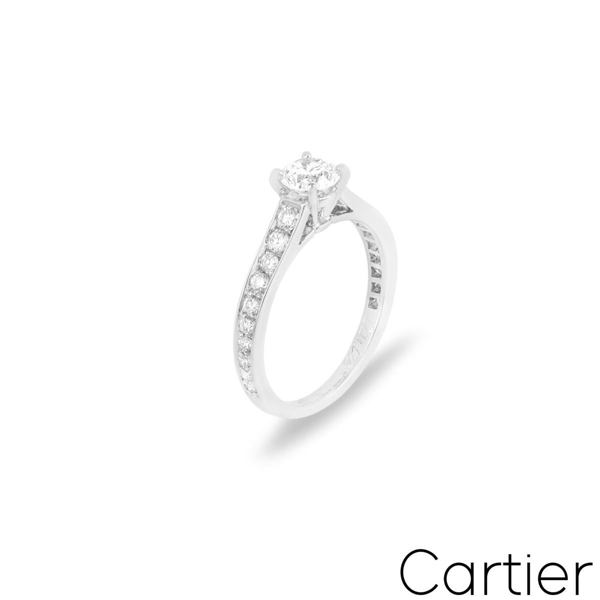 A gorgeous platinum Cartier diamond ring from the 1895 collection. The engagement ring comprises of a round brilliant cut diamond in a four claw mount weighing 0.35ct, G colour and VVS2 clarity. The ring features 10 round brilliant cut diamonds