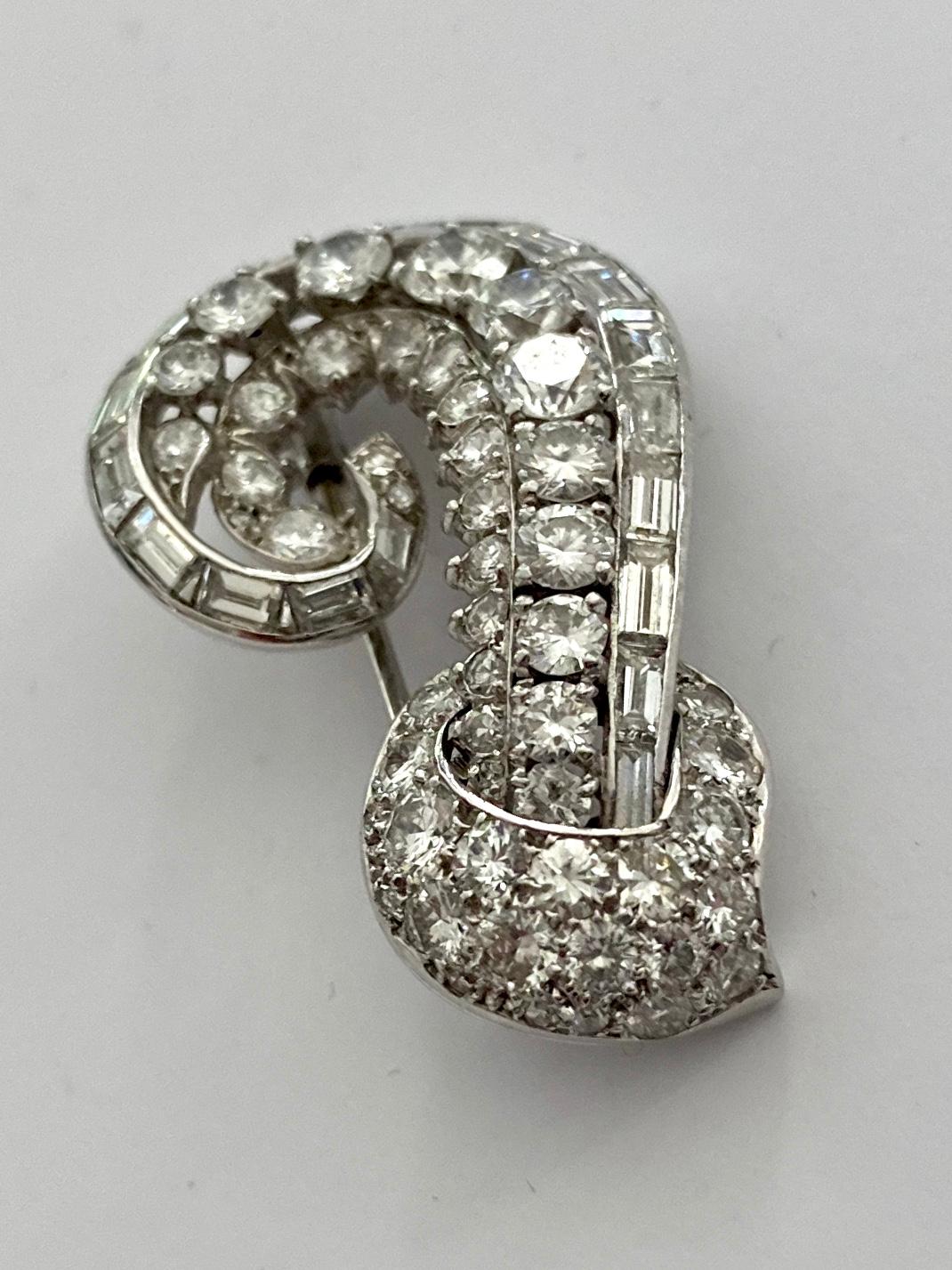 One (1) White Platinum Brooch, signed: Cartier London.
Clip mechanique, 
set with:
36 brillant cut daimonds 3.00ct  VVS/VS -D-E
10 single cut diamaonds 0.20ct  VVS/VS - D-E
19 baquette cut diamonds 2.00 ct  VVS/VS - D-E
weight: 10.43
