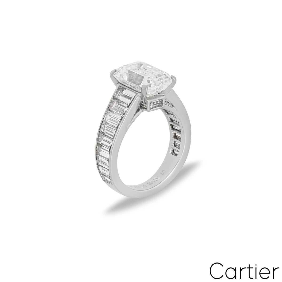 An extraordinary platinum diamond engagement ring by Cartier. The ring is set to the centre with an emerald cut diamond weighing 4.12ct, E colour and VVS2 clarity. Complimenting the central diamond are 18 baguette cut diamonds set to the shoulders