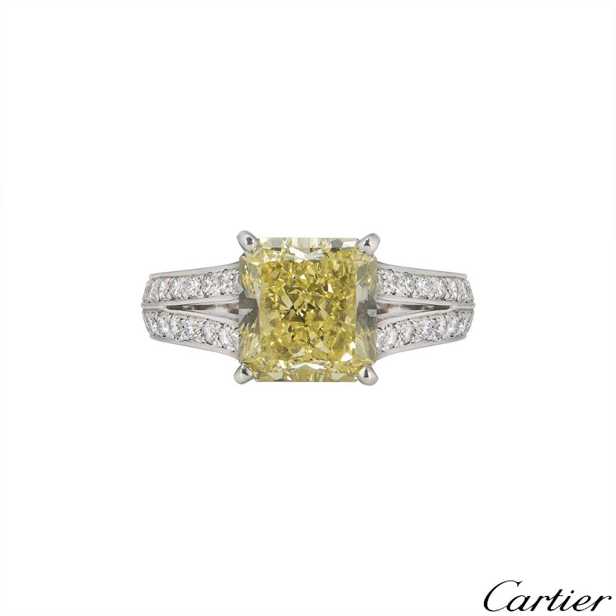 A platinum diamond ring by Cartier from the Adele collection. The ring is set with a radiant cut diamond with a weight of 3.90ct with a fancy intense yellow colour and VVS2 clarity. The centre stone is set within four claws and has diamond set