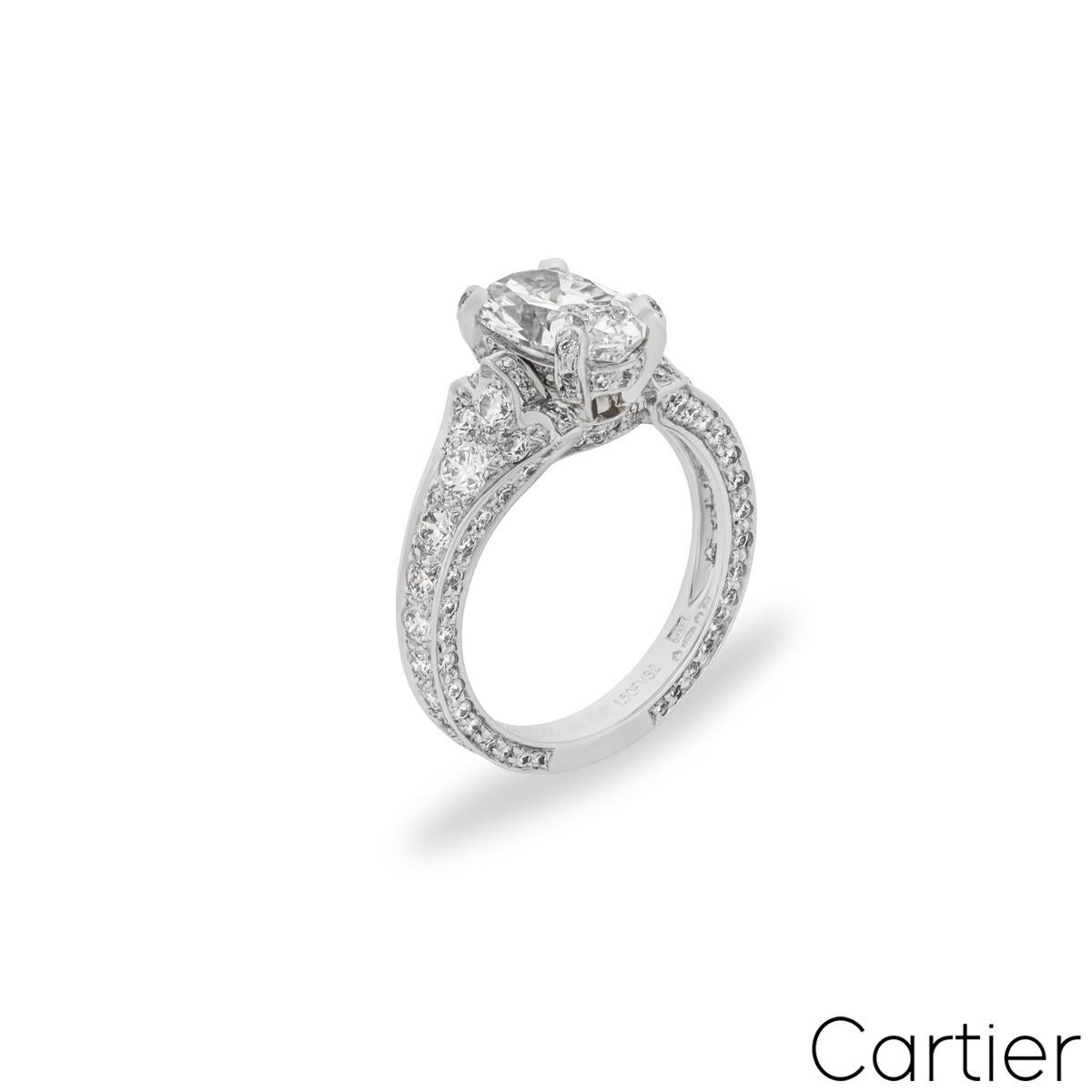 A magnificent platinum diamond engagement ring by Cartier from the Camelia collection. Adorning the centre in an elaborate diamond set four prong mount is an oval cut diamond weighing 1.50ct, F colour and VS2 clarity. Accentuating the centre stone