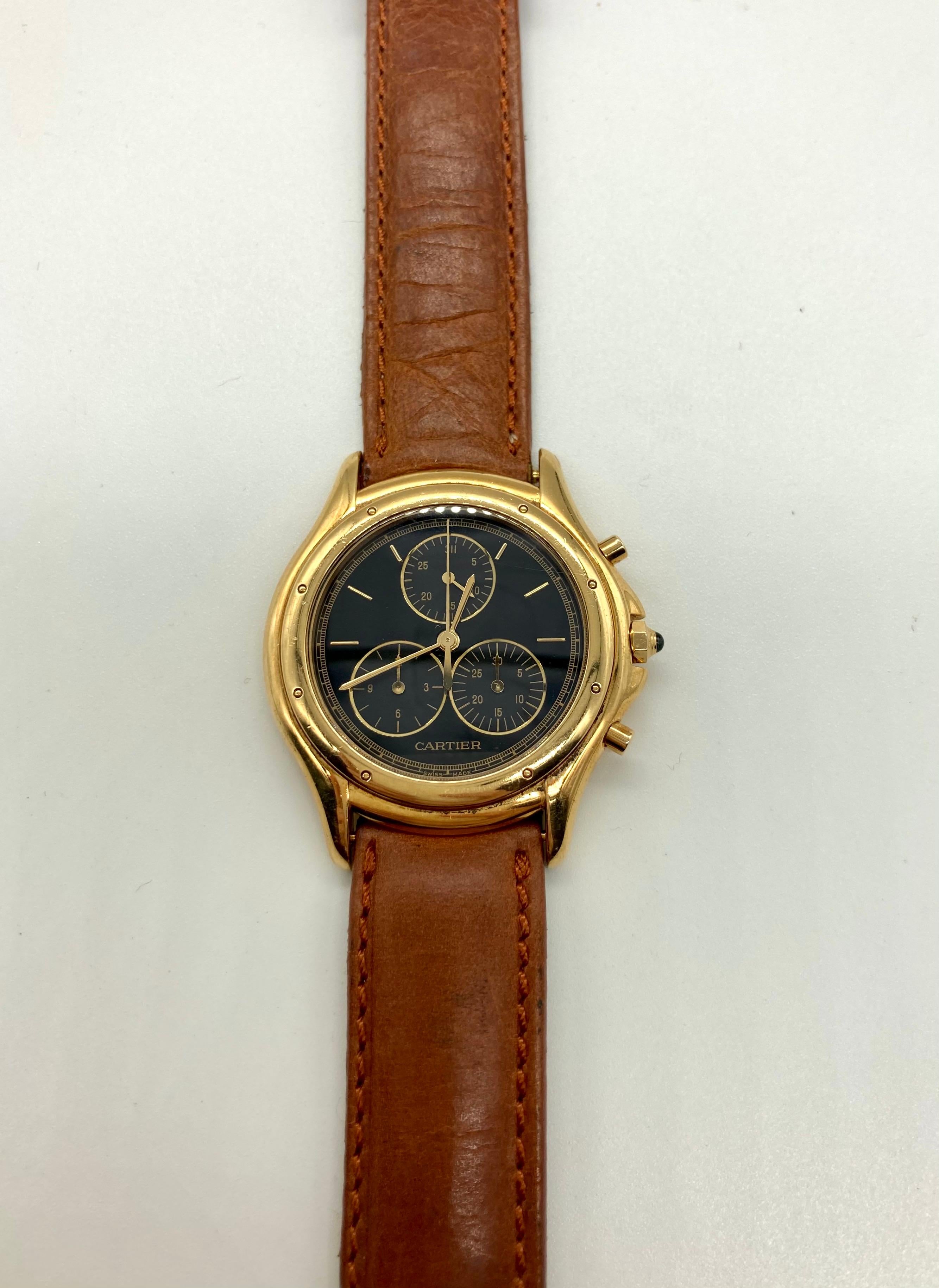 Une chic montre chronographe à quartz Cartier en or jaune 18 carats, avec un bracelet en cuir. Fabriqué en Suisse, vers 1980.
