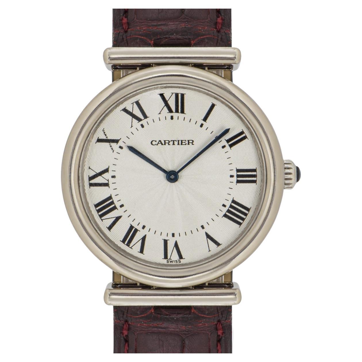 Rare montre-bracelet Vendome Drivers 32 mm pour dame, en or blanc, réalisée par Cartier. Cadran argenté guilloché avec chiffres romains appliqués, aiguilles en forme de glaive en acier bleui et signature cachée de Cartier au niveau du 