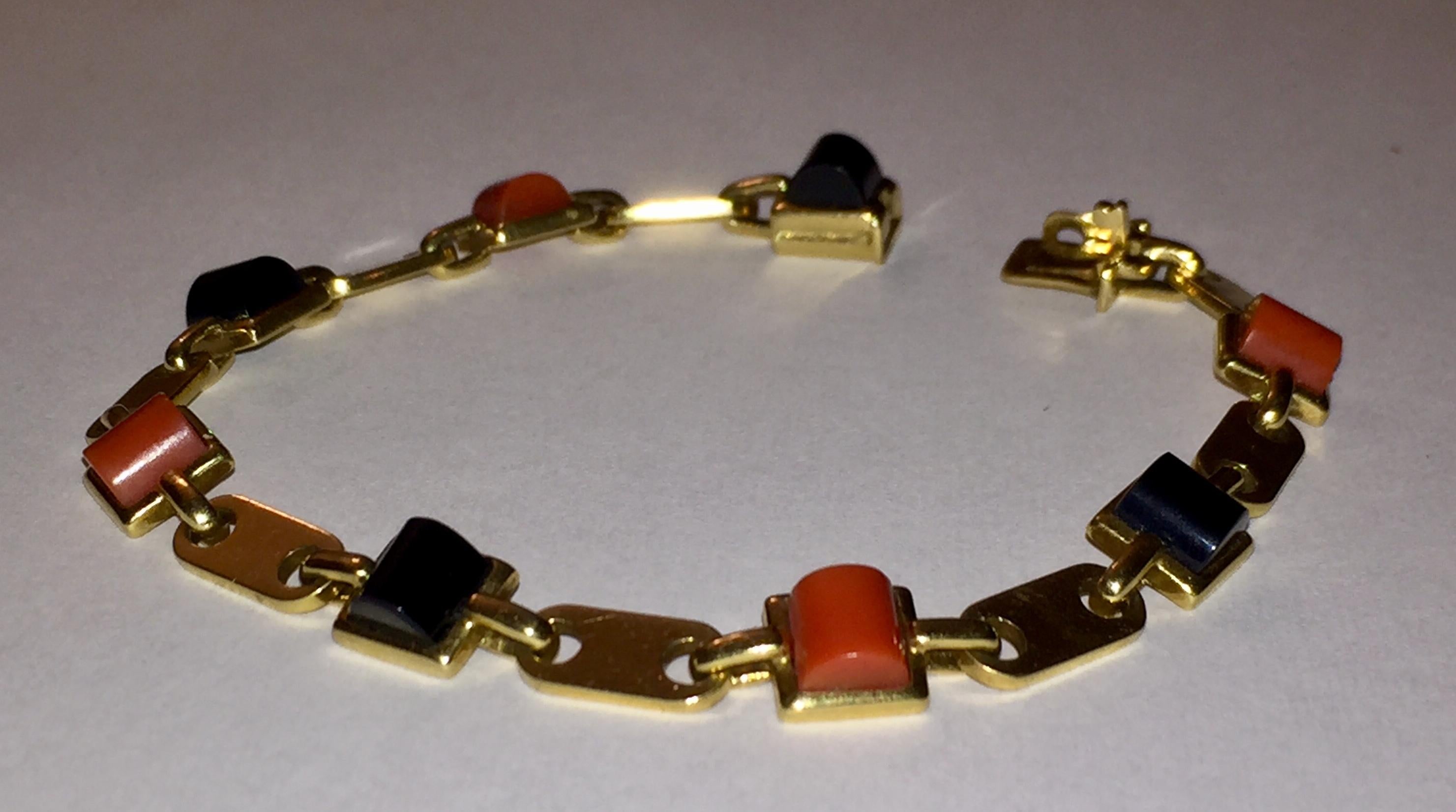 Cartier 18 karat yellow gold bracelet with half cylinder shaped natural red coral and black onyx. Measures 7.5” by 0.25” wide. Marked, Cartier 750, 59493. Circa, 1980s. Weighs, 21.2 grams. 