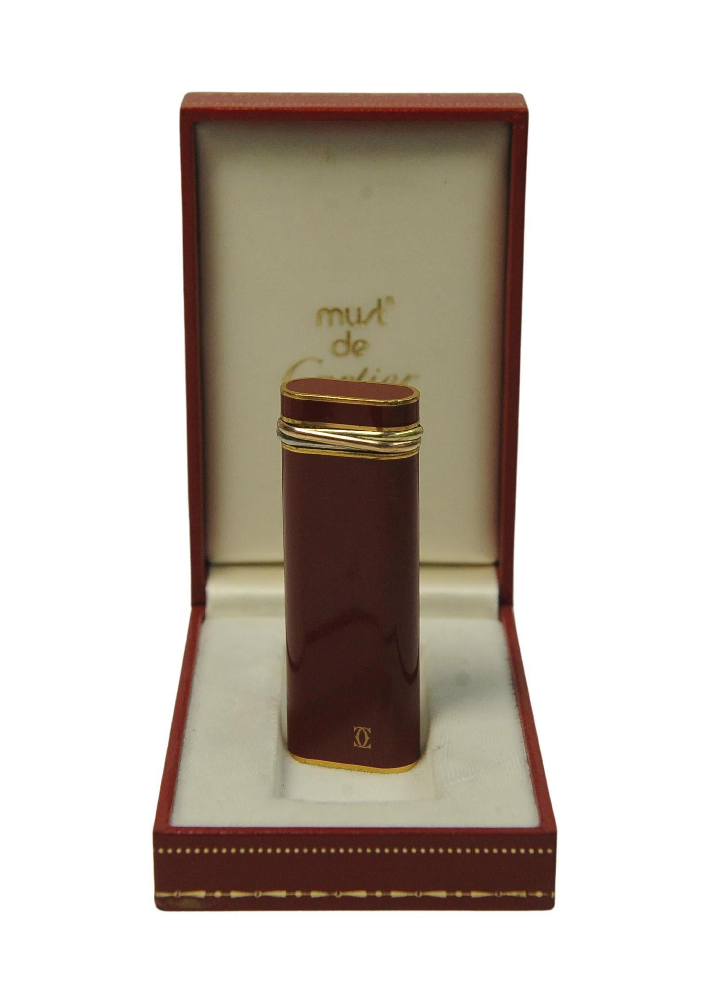 Elegant briquet trinitaire en laque rouge à 3 bandes plaqué or 18ct Must De Cartier avec boîte et garantie

Le briquet a été révisé

Marqué Cartier Paris à la base du briquet 

Complet avec boîte d'origine, instructions 

