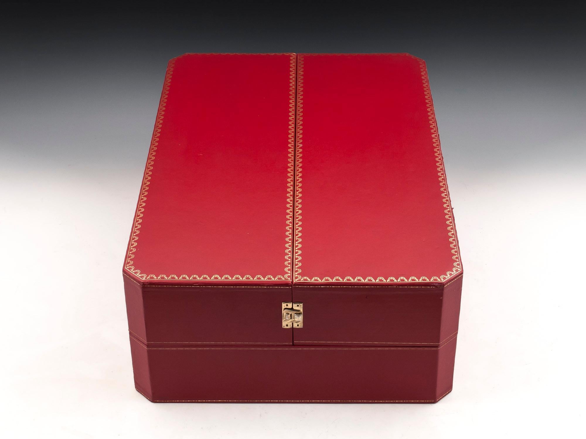 Large red leather bound backgammon box by Cartier with fine gold detailing and two brass clasps either side to keep the box secure when closed. 

Opening this fabulous Cartier games box reveals a large vibrant red and white backgammon board, flanked