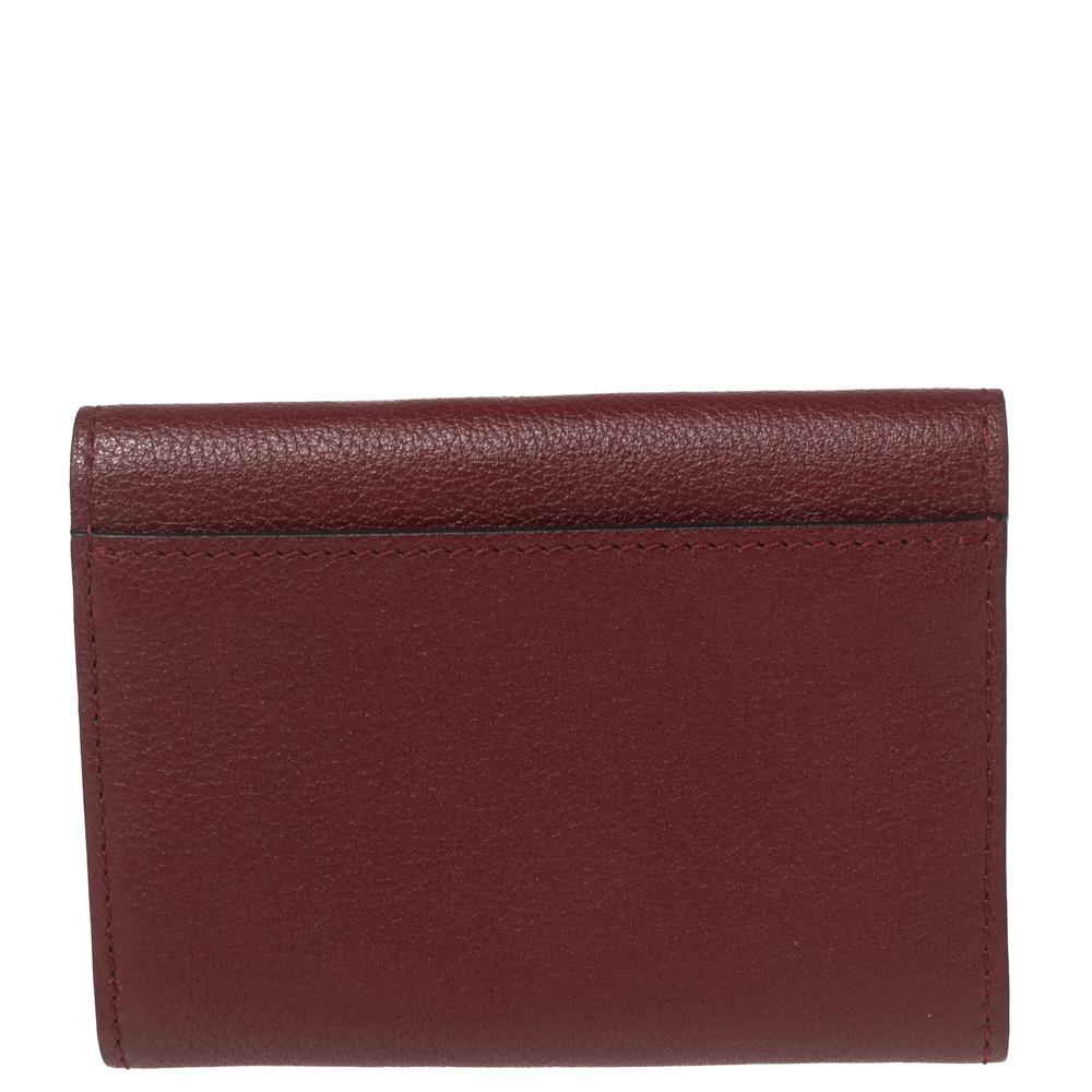 Designed to perfection using fine quality leather, this wallet will be an ideal everyday accessory. This C de Cartier wallet comes in a compact silhouette, beautified by a red shade and a metal-tipped flap that opens to ample space for your monetary